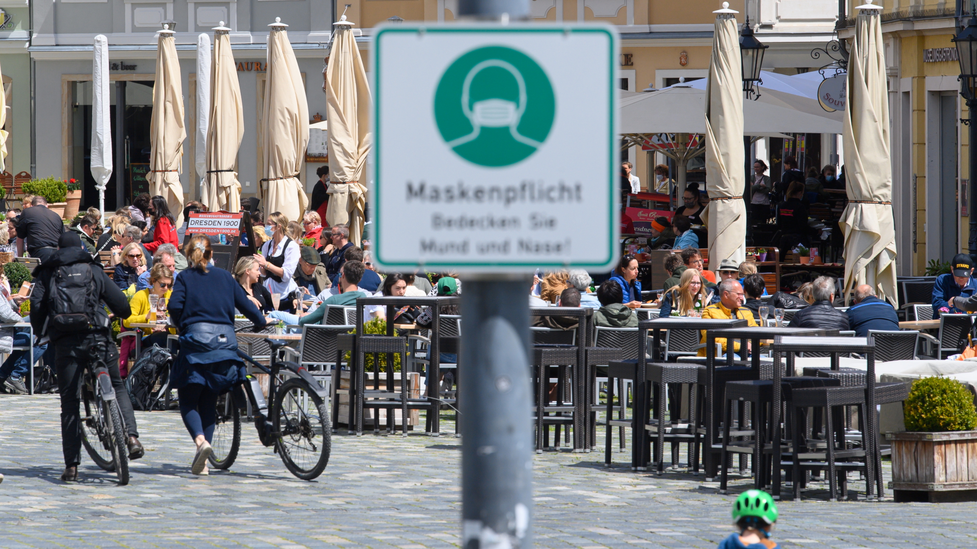 Menschen sitzen vor einem Café in der Fußgängerzone in Dresden | dpa