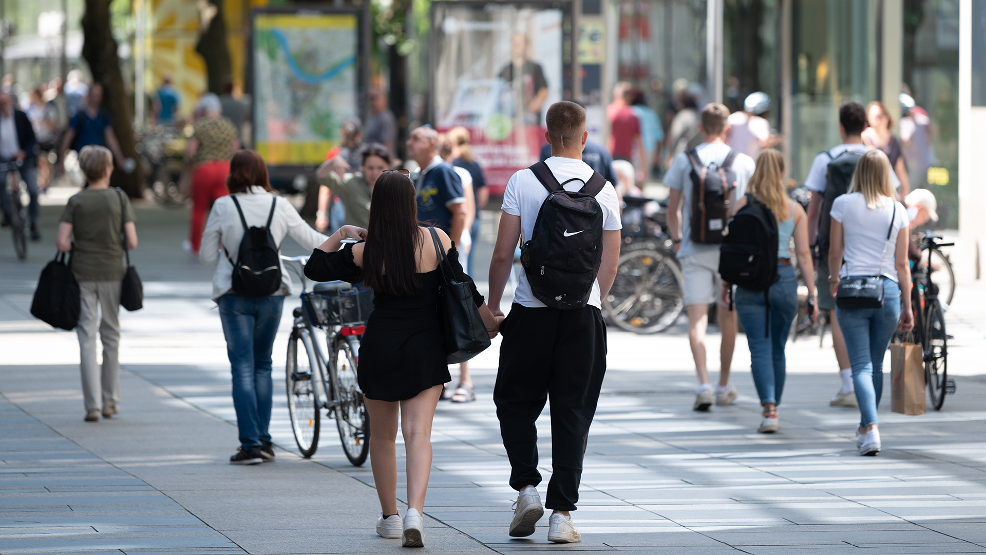 Passanten gehen auf einer Einkaufsstraße in Dresden (Sachsen) an den Geschäften entlang. | dpa
