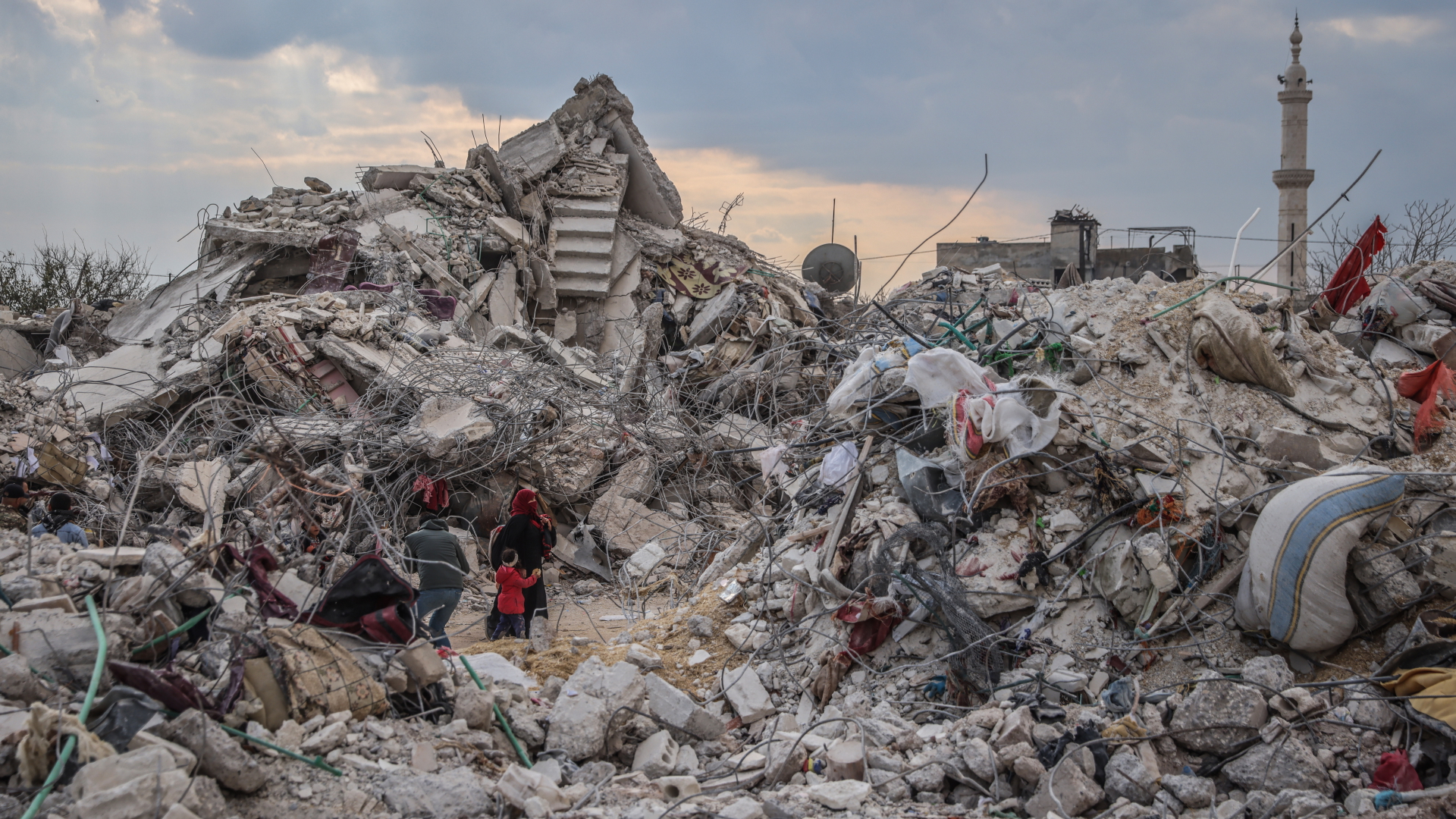 Menschen laufen durch Haufen von Trümmern in Dschindires, Syrien. | dpa