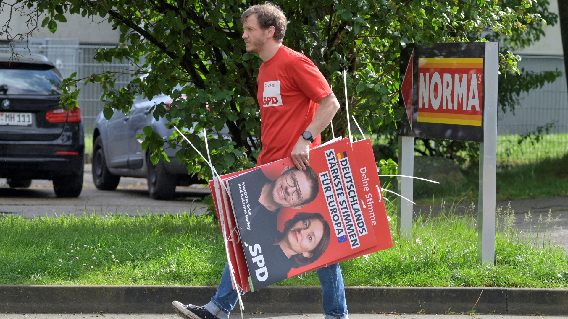 Ein Wahlhelfer trägt Plakate der SPD-Europakandidaten Matthias Ecke und Katarina Barley