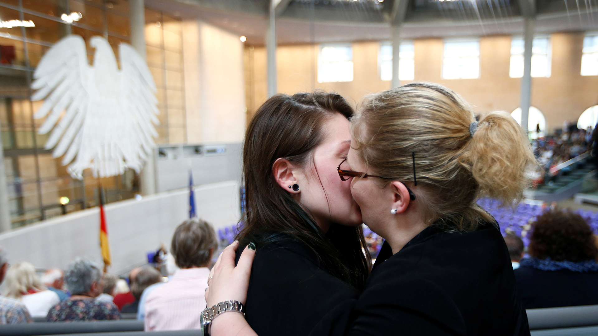 Zwei Frauen küssen sich auf der Zuschauertribüne des Bundestages. | REUTERS