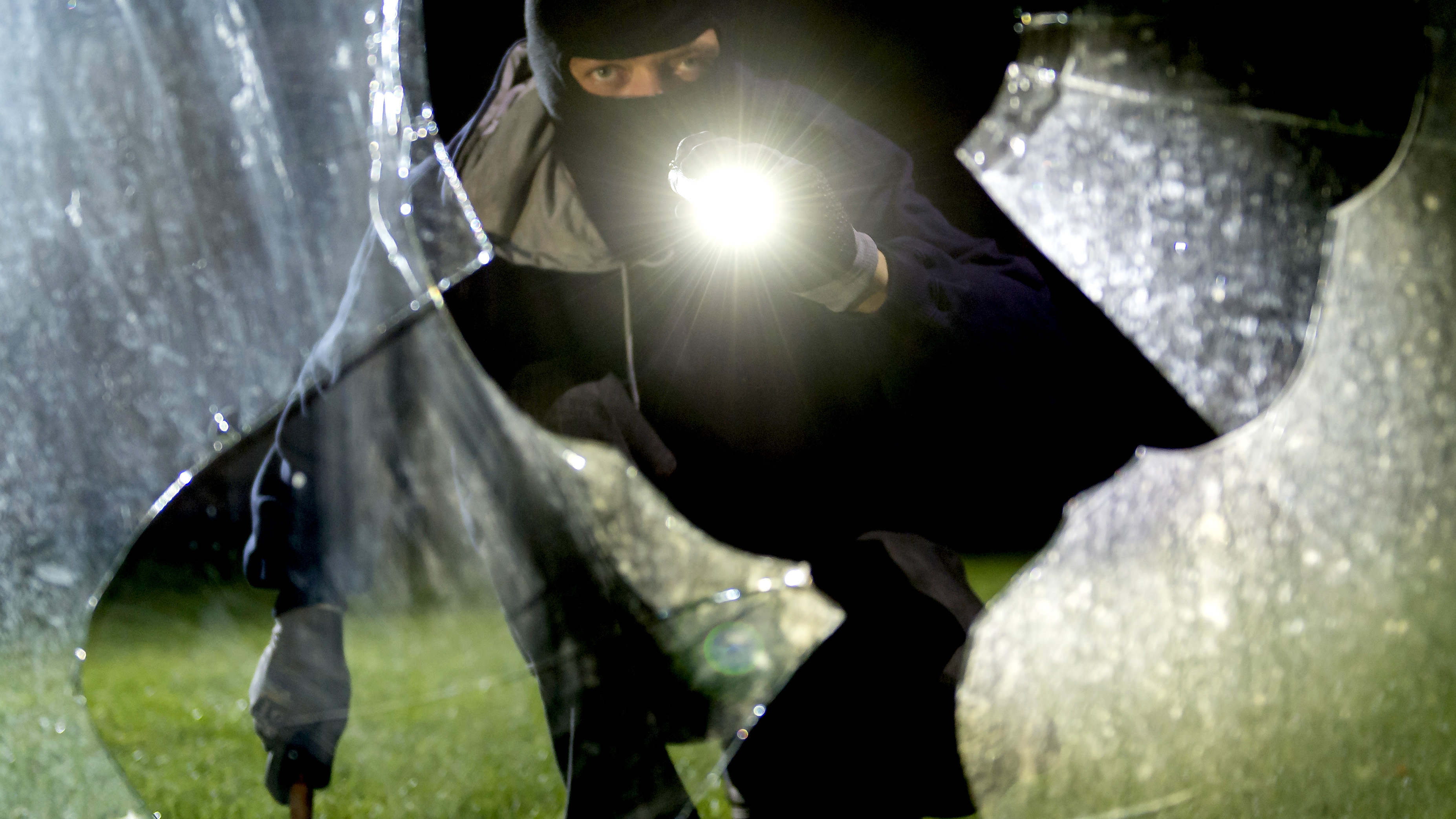 Symbolfoto eines Einbrechers hinter einer eingeschlagenen Scheibe | picture alliance / Daniel Maurer
