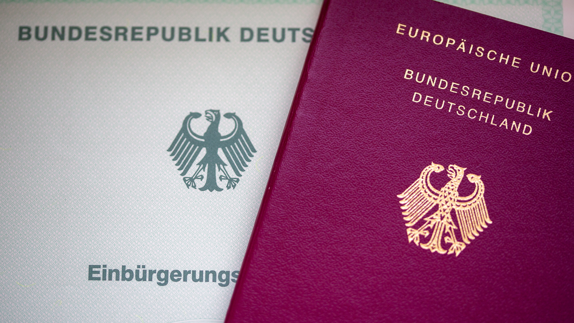 Eine Einbürgerungsurkunde liegt neben einem Reisepass