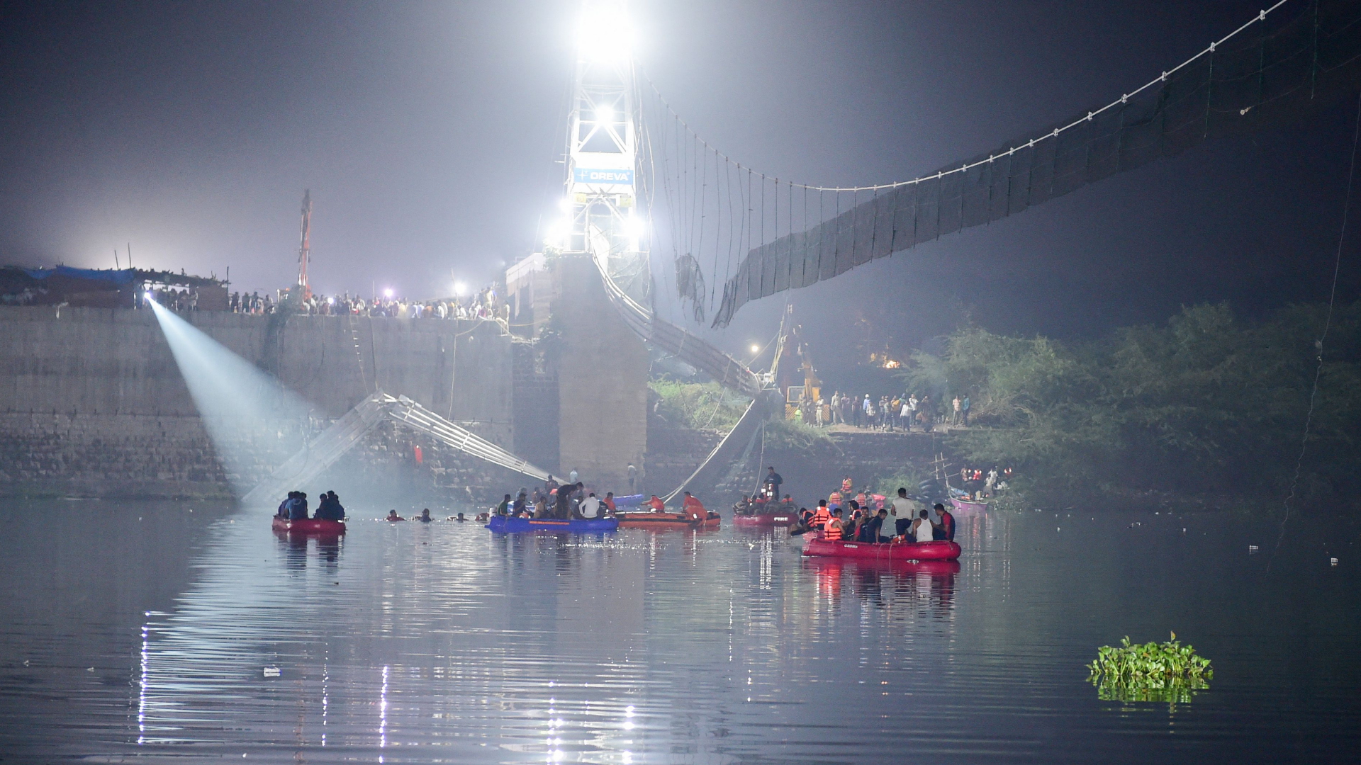 Rettungskräfte auf dem Fluss Machchhu, unter Resten der kollabierten Brücke. | AFP