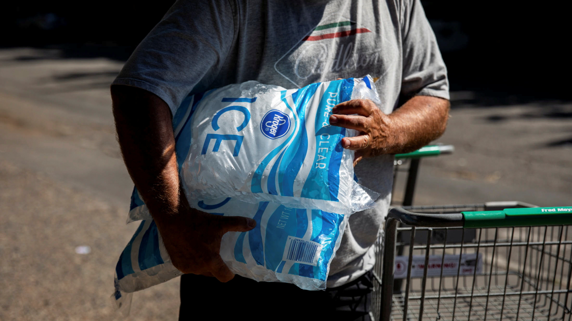 Ein Supermarktkunde in Oregon hält zwei Großpackungen Eiswürfel im Arm. | REUTERS
