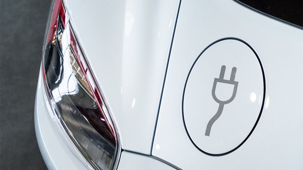 Ein Aufladeklappe mit einem Steckersymbol an einem Elektroauto. | null