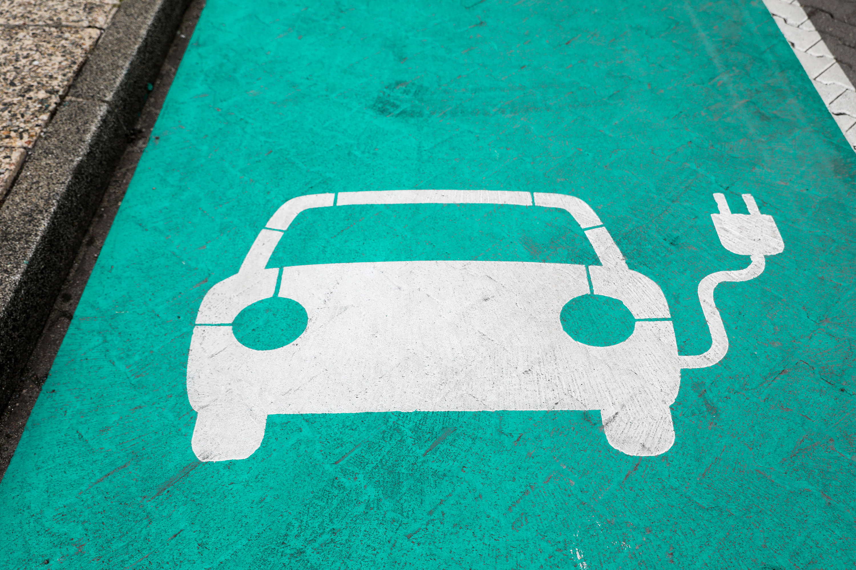 Piktogramme auf einer Straße zeigen Haltepunkte für Elektroautos an einer Ladesäule | dpa