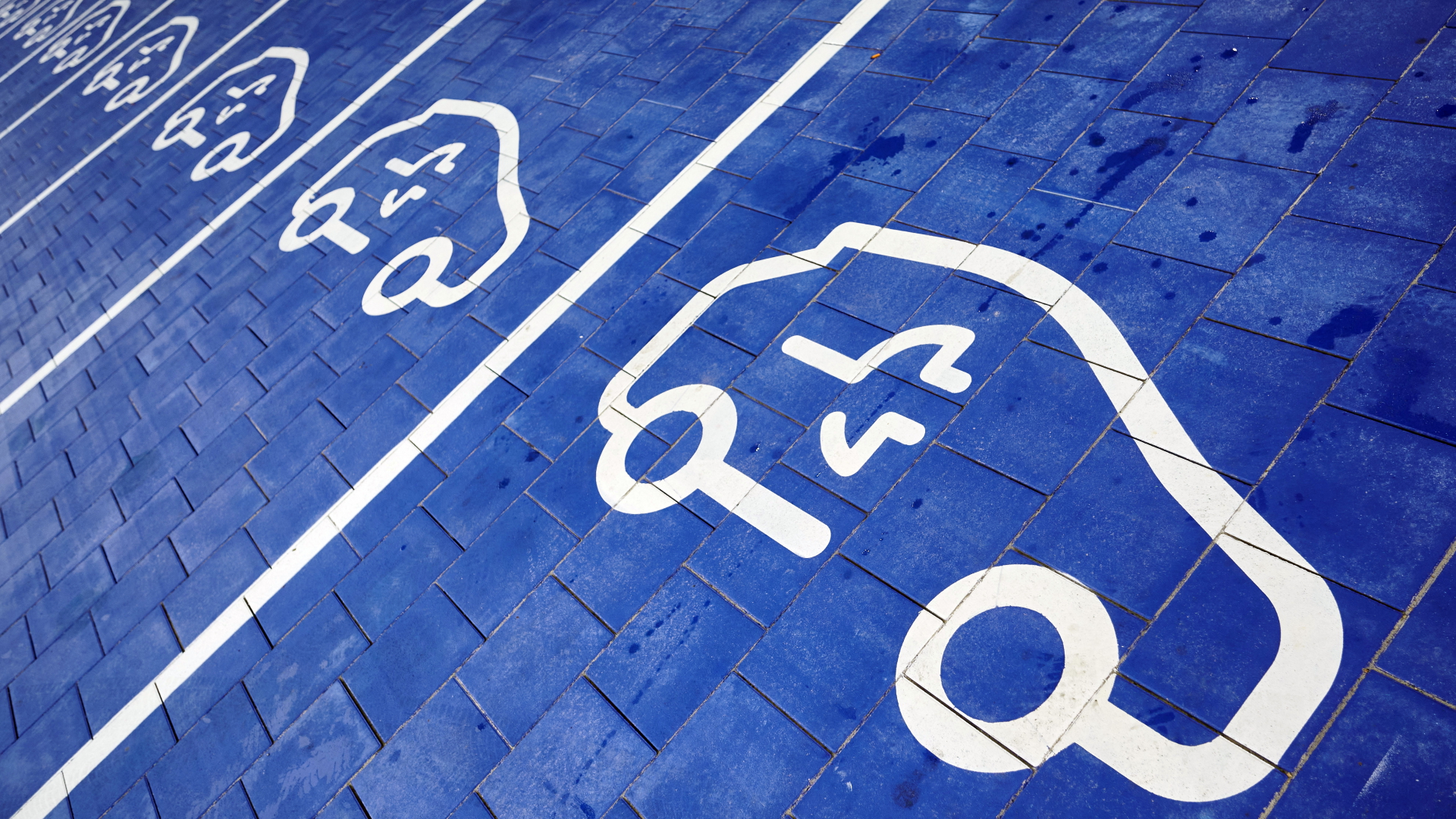 Symbole für Elektroautos sind auf Parkplätze gemalt | dpa