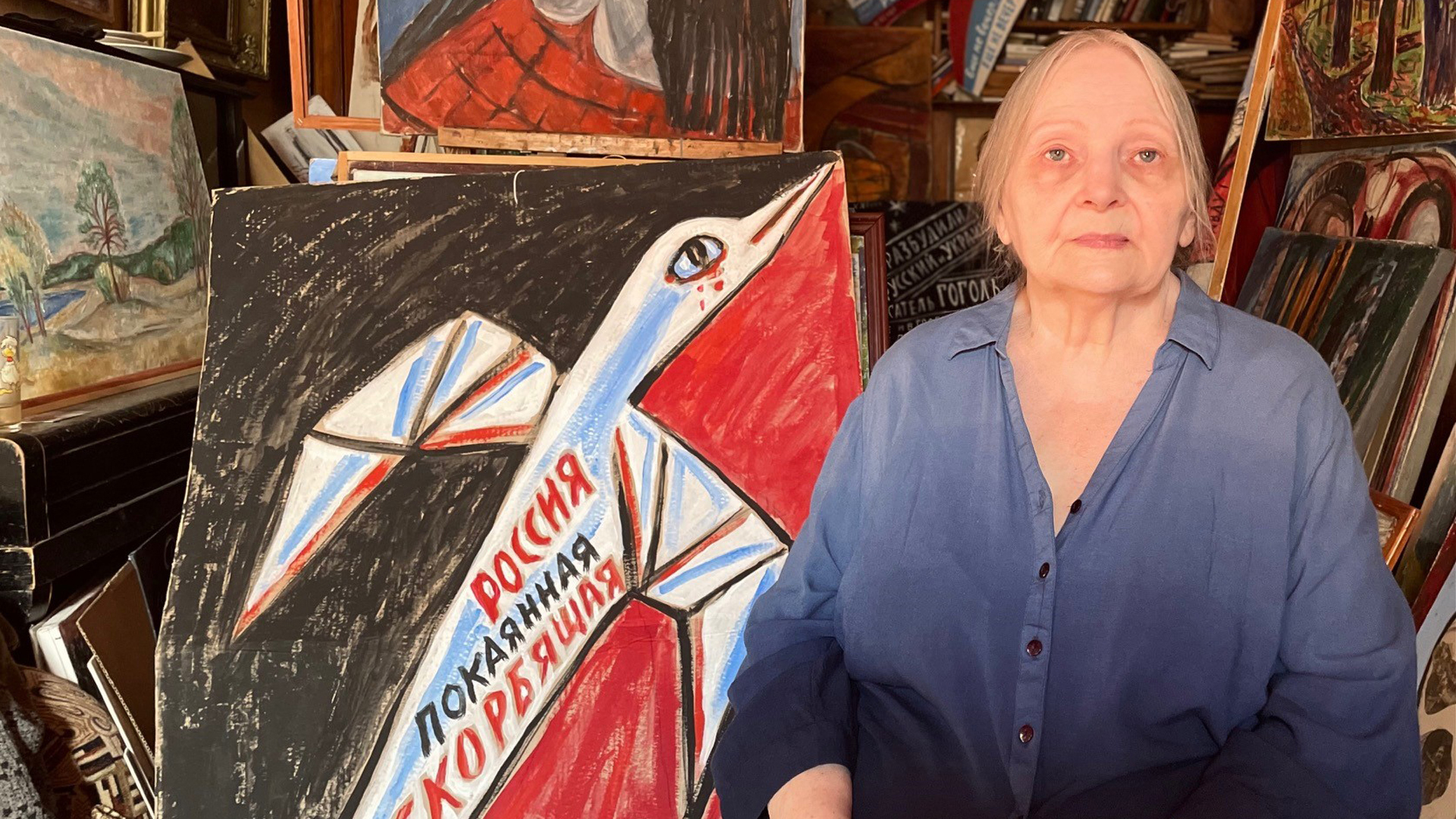 Die Malerin Elena Osipowa steht vor mehreren Bildern. | Martha Wilczynski/ARD-Studio Moskau
