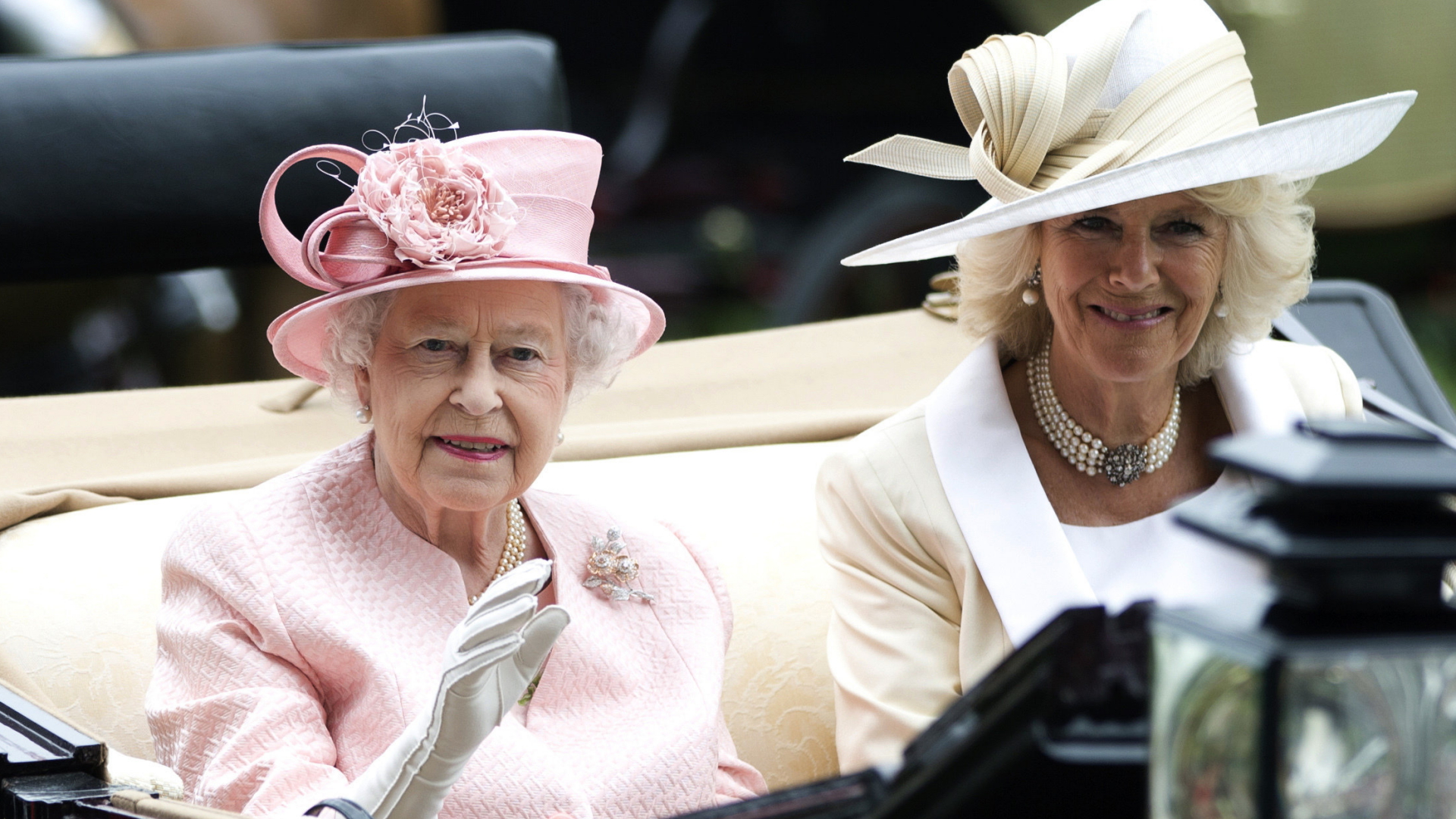 Britische Königin Elizabeth II. und Herzogin Camilla winken bei einer Fahrt in einem offenen Wagen im englischen Ascot (Foto vom 18. Juni 2013). | AP