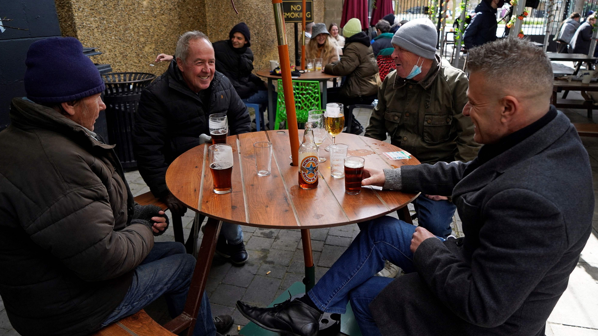 Vier Herren sitzen mit einem Bier in einem Pub im Osten Londons.