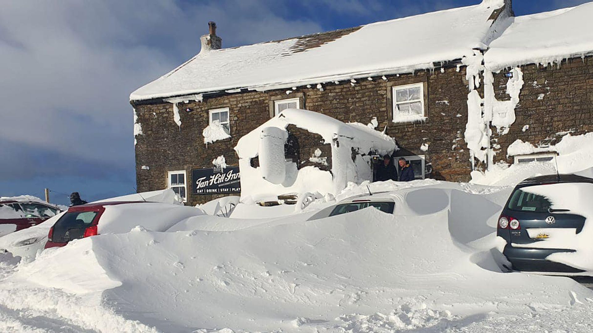 Schnee liegt um den eingeschneiten Pub "Tan Hill Inn" im nordenglischen Nationalpark Yorkshire Dales herum. | dpa