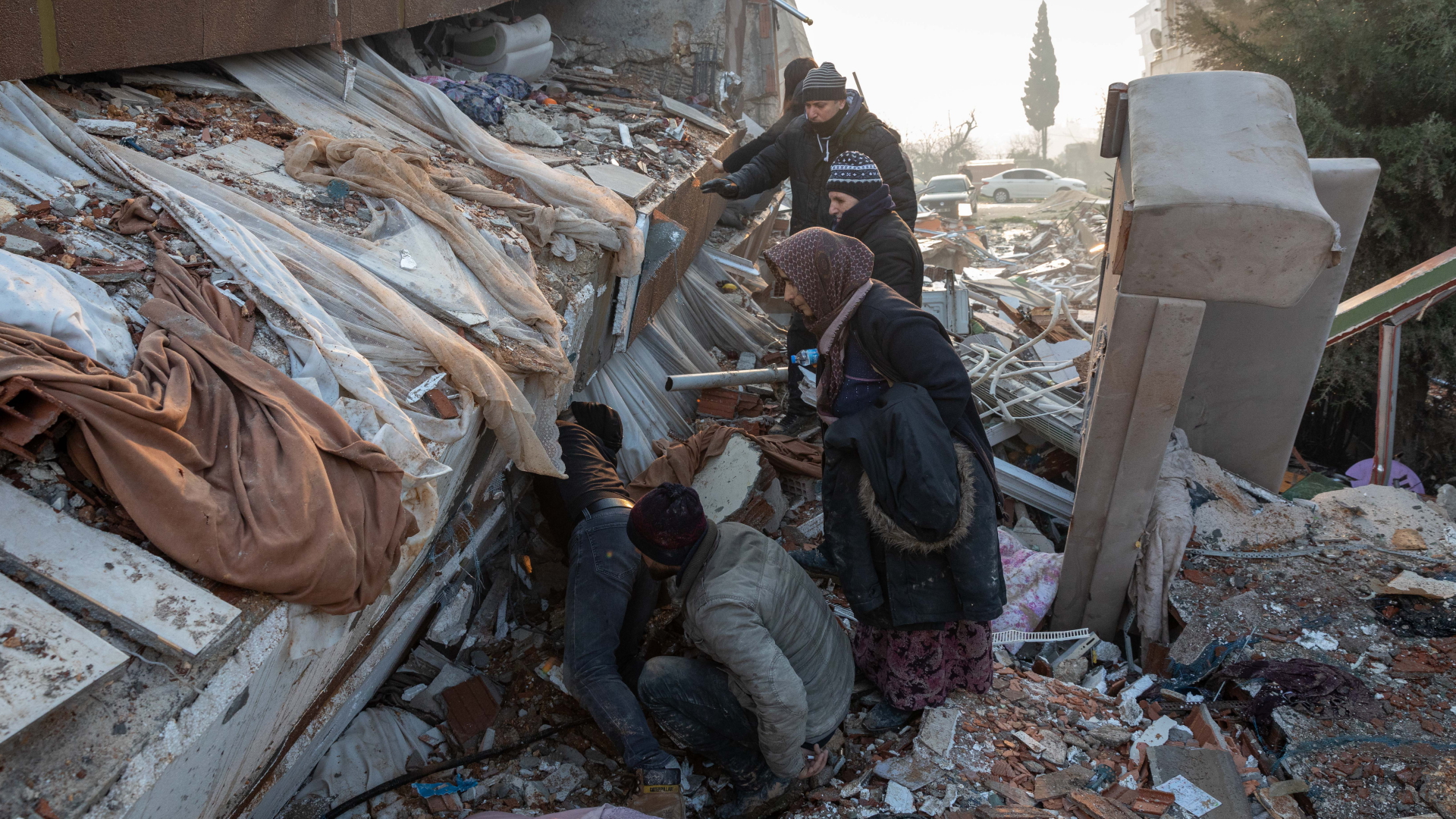 Menschen sind in Antakya in der Türkei auf der Suche nach Überlebenden in Trümmern. | dpa