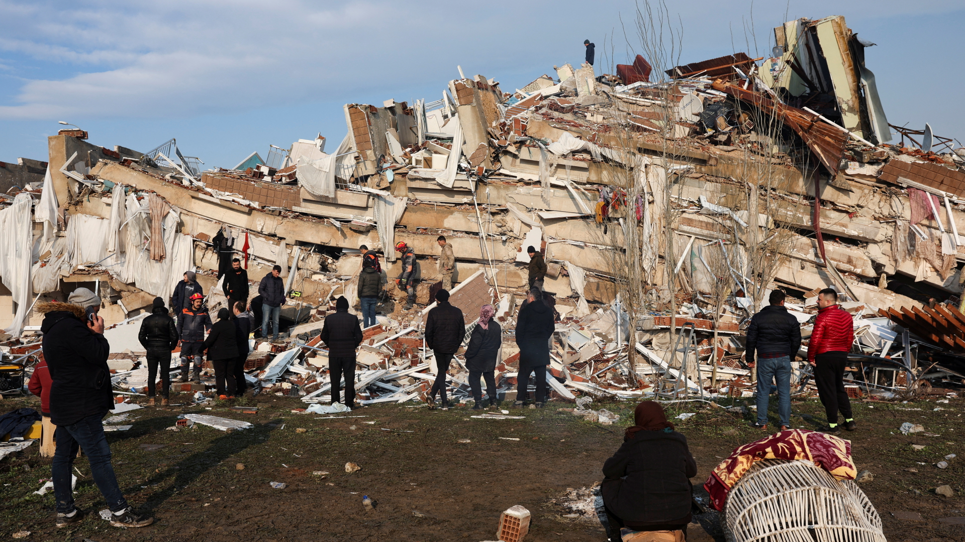 Menschen suchen in einem zerstörten Gebäude in der Provinz Hatay in der Türkei nach Überlebenden. | REUTERS