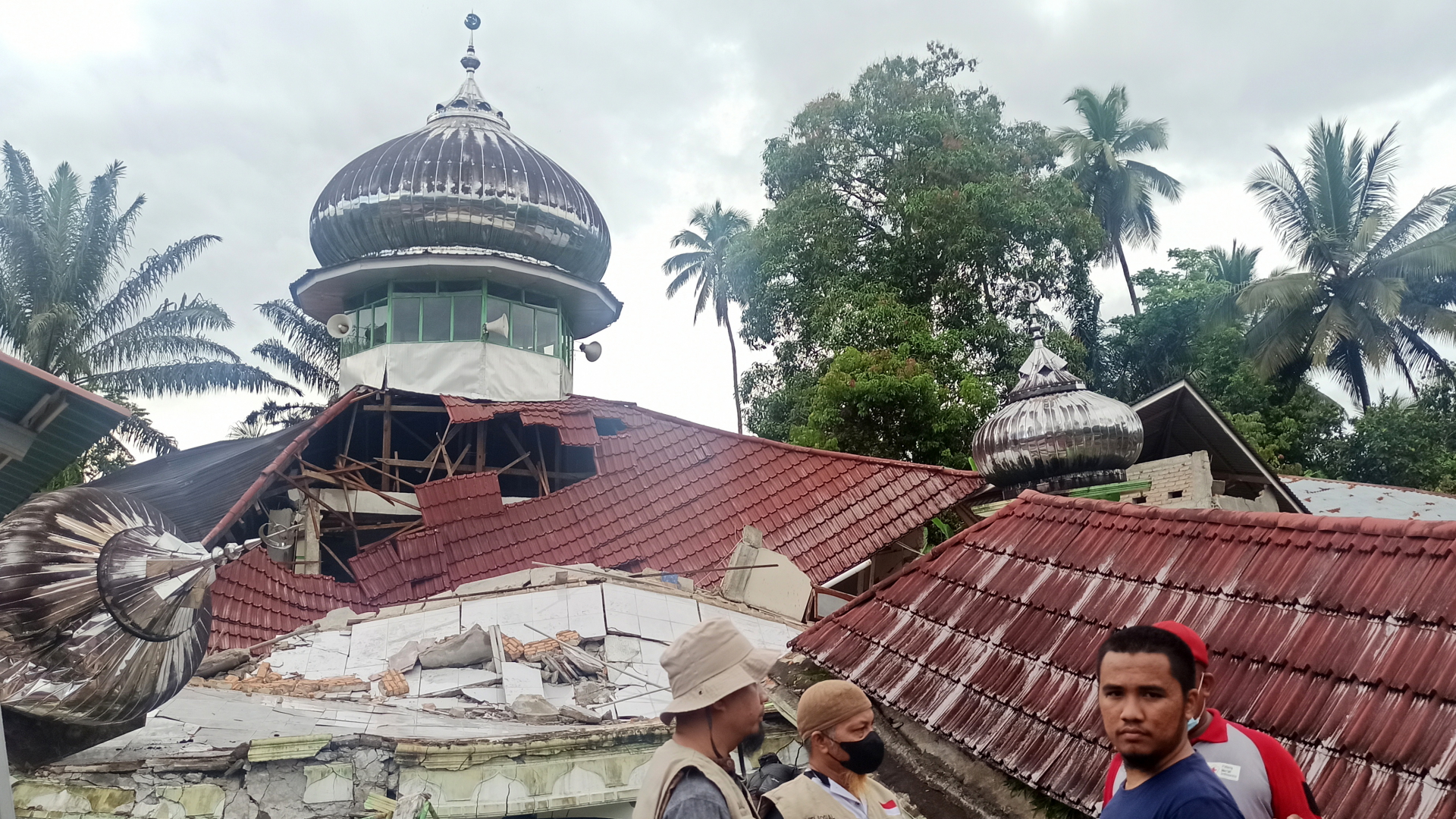 Menschen stehen vor einer durch ein Erdbeben zerstörten Moschee im indonesischen Bezirk Pasaman | dpa