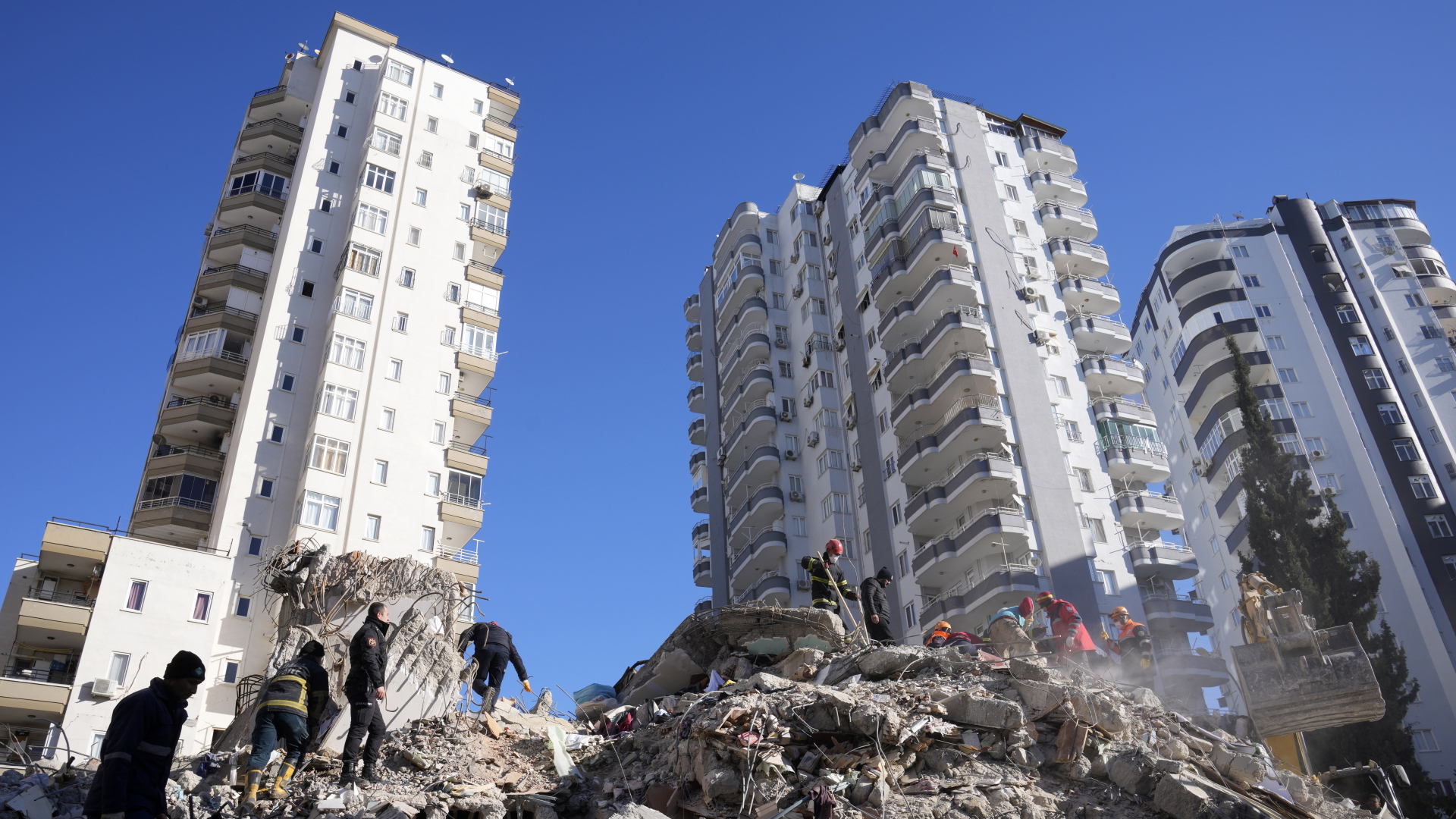 Notfallteams suchen nach Menschen in den Trümmern eines zerstörten Gebäudes in Adana | dpa