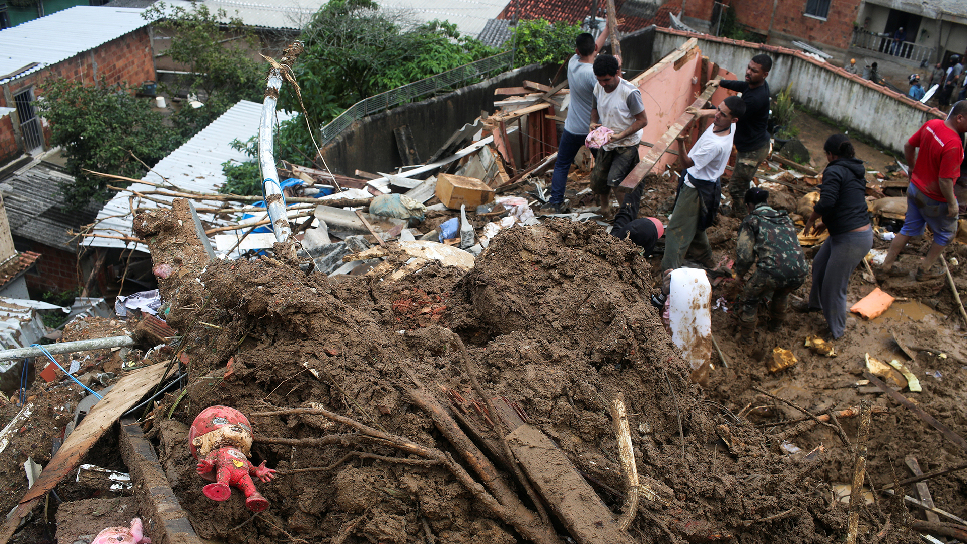 Menschen stehen in einer Schlammlawine in Petrópolis. | REUTERS