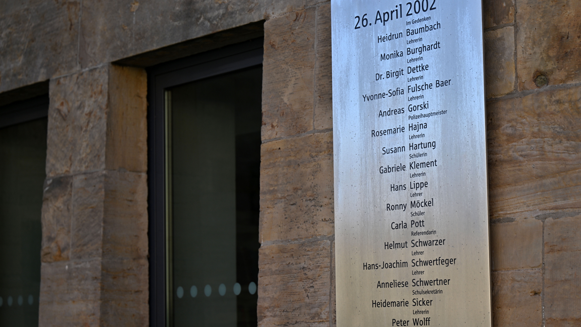  Eine Gedenktafel mit den Namen der Opfer am Gutenberg-Gymnasium 20 Jahre nach dem Amoklauf.  | dpa