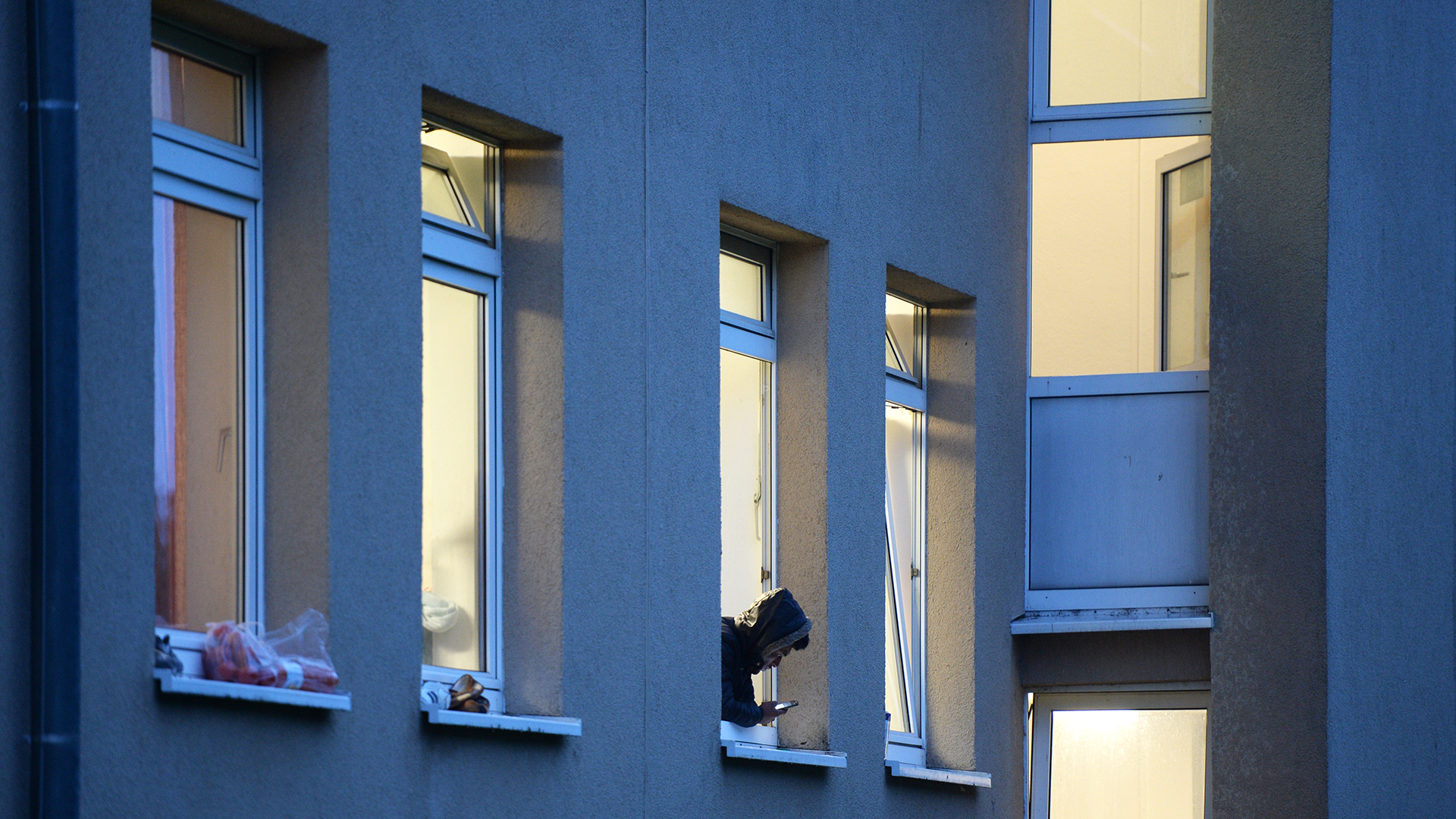 Ein Asylbewerber lehnt sich in der Erstaufnahmestelle für Flüchtlinge in Meßstetten aus dem Fenster. (Archivbild: 18.06.2015) | picture alliance / dpa