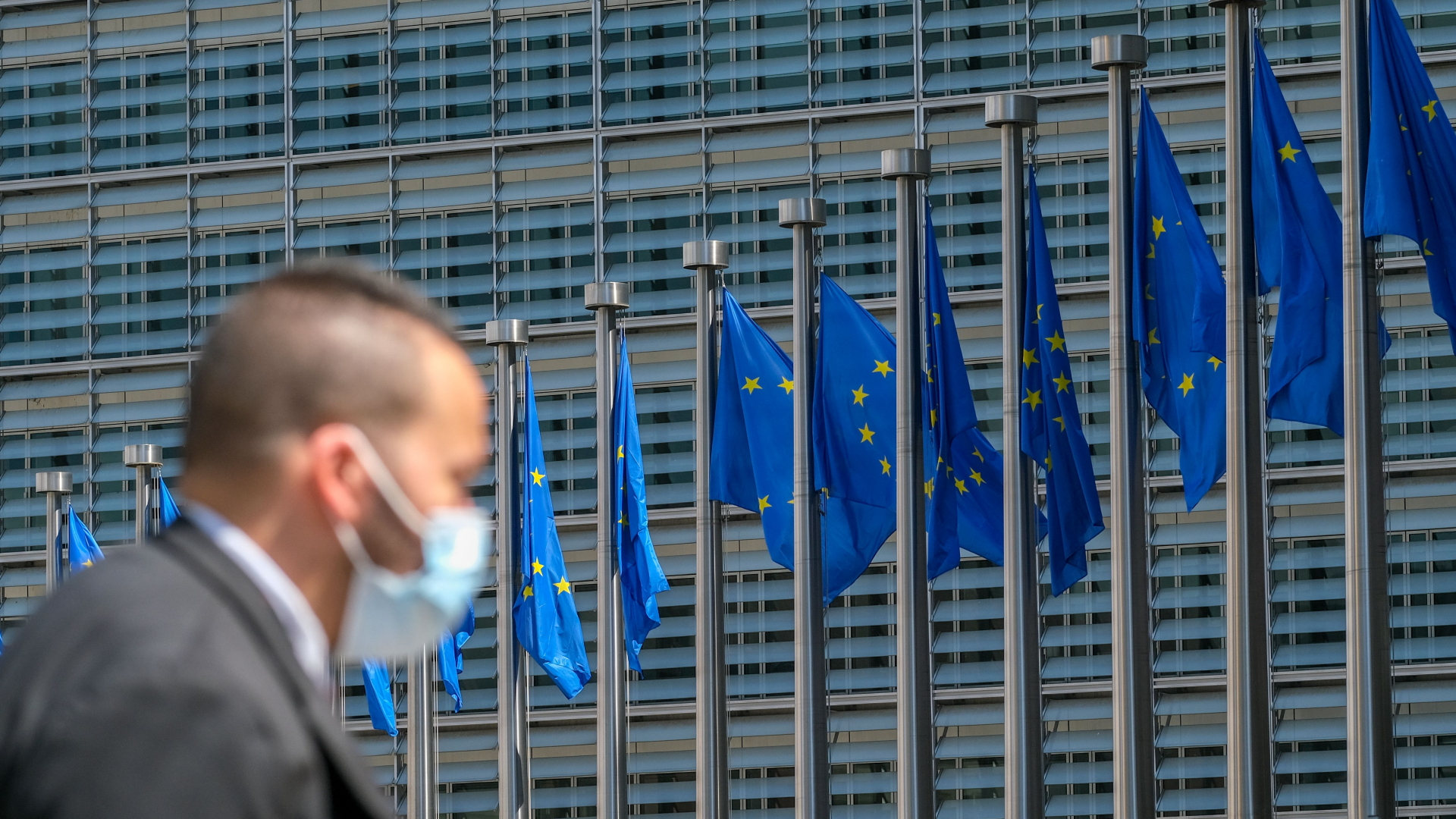 Ein Mann mit Maske vor dem Berlaymont-Gebäude der EU in Brüssel (Archivbild)