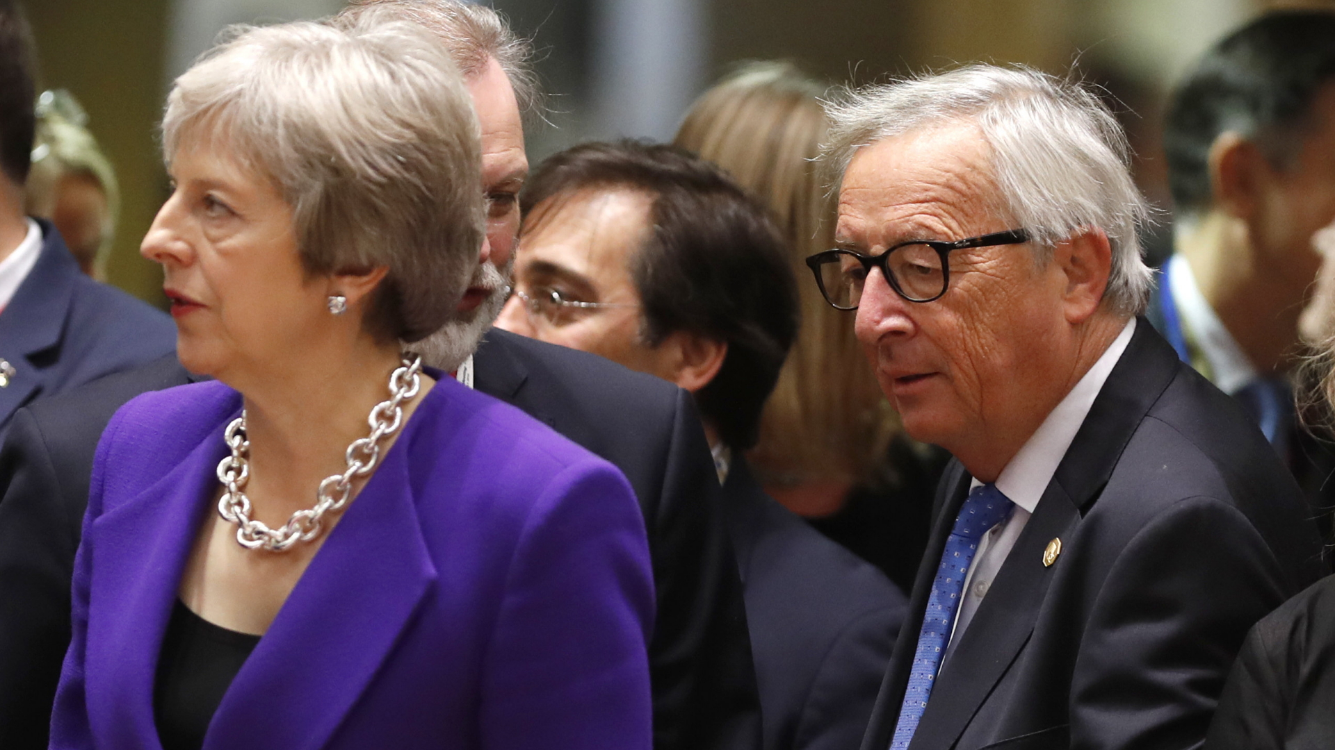 Die britische Premierministerin Theresa May und EU-Kommissionschef Jean-Claude Juncker in einer Menschenmenge. | Bildquelle: AP