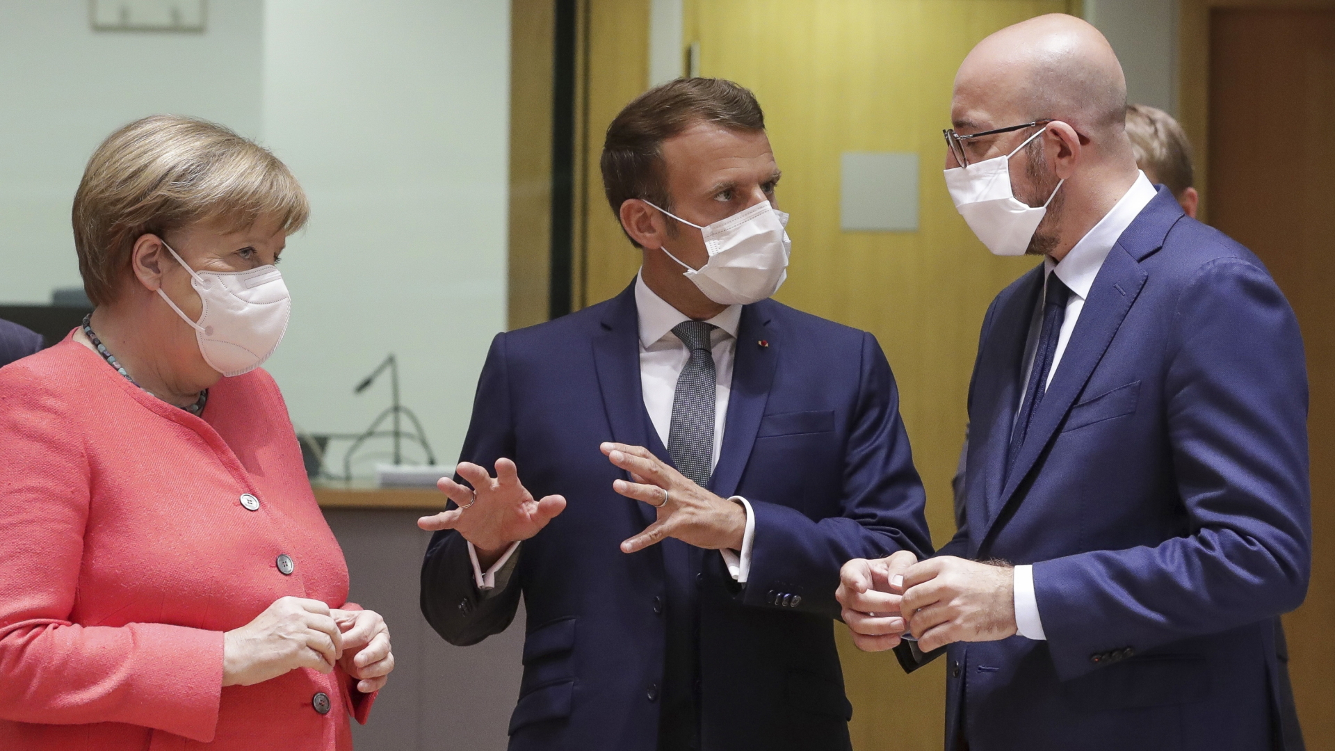 Charles Michel (r), Präsident des Europäischen Rates spricht mit Bundeskanzlerin Angela Merkel (CDU) und Emmanuel Macron, Präsident von Frankreich, bei ihrem Eintreffen zu einem Rundtischgespräch beim EU-Gipfel. | dpa