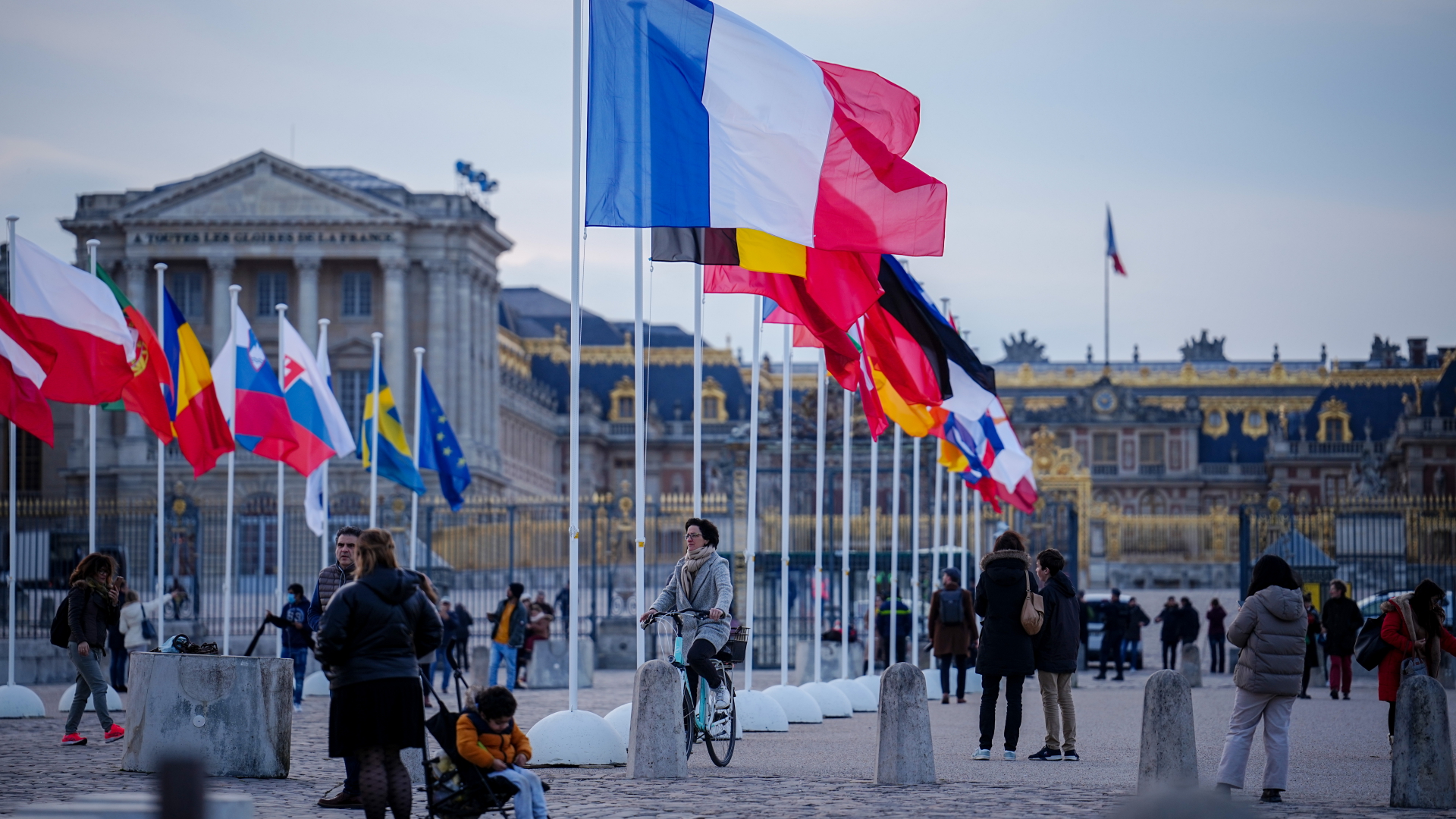 Die Fahnen der EU-Mitgliedsstaaten wehen vor dem Schloss in Versailles im Wind.  | dpa