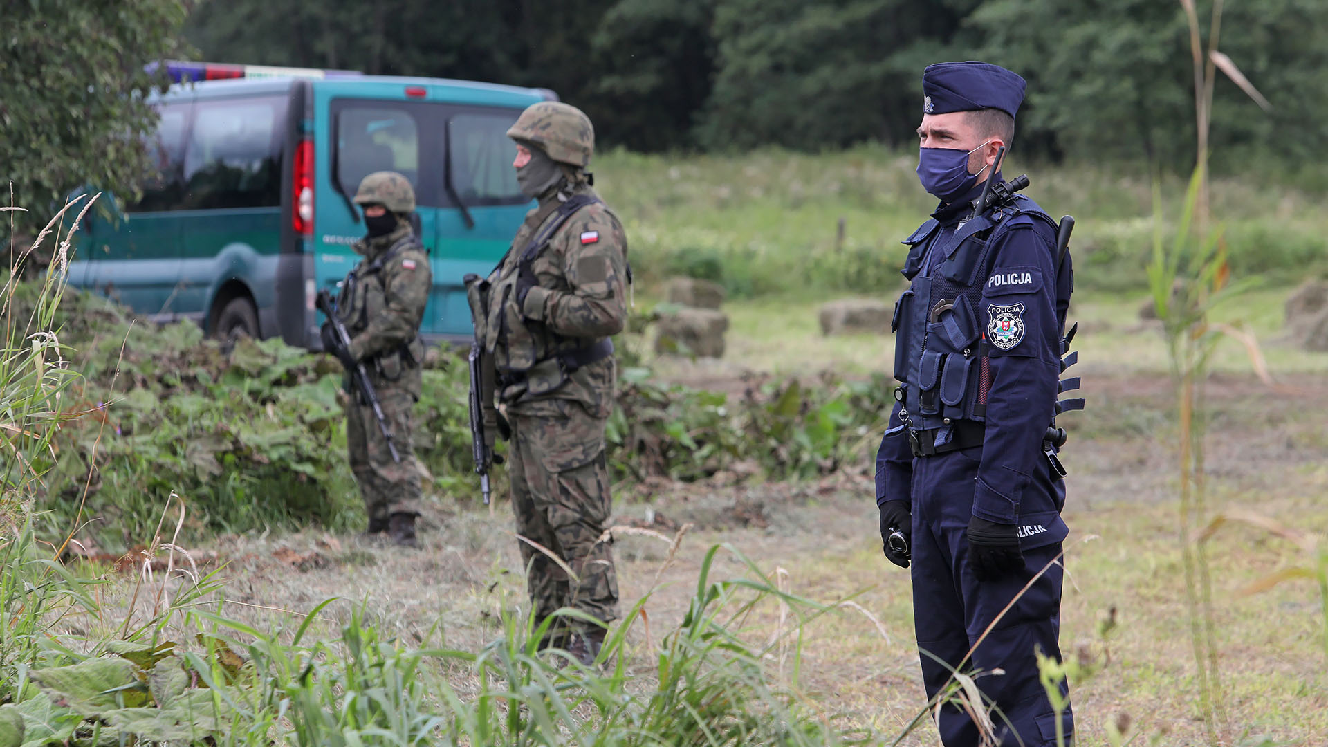 Soldaten und eine Polizist an der EU-Außengrenze zwischen Polen und Belarus. | EPA