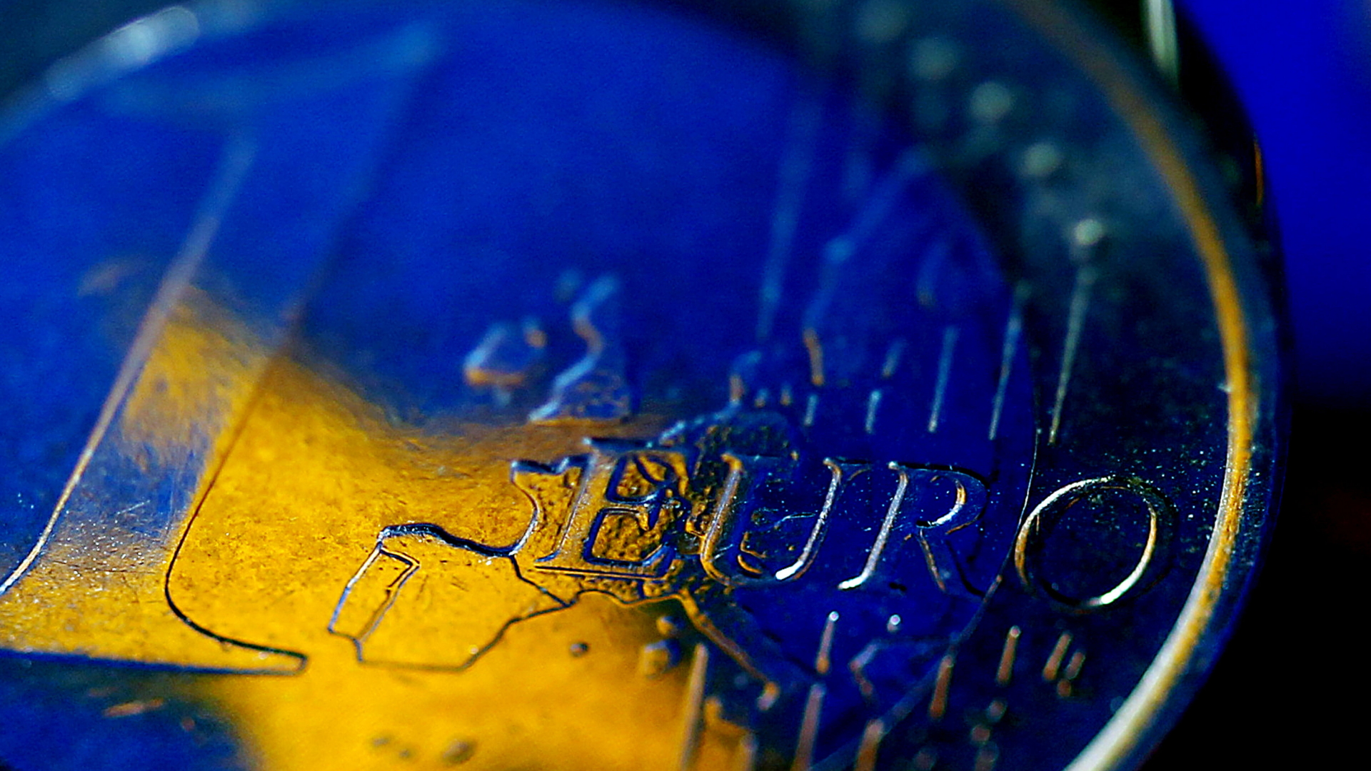 Die Fahne der Europäischen Union (EU) spiegelt sich in einer Euro-Münze. | dpa