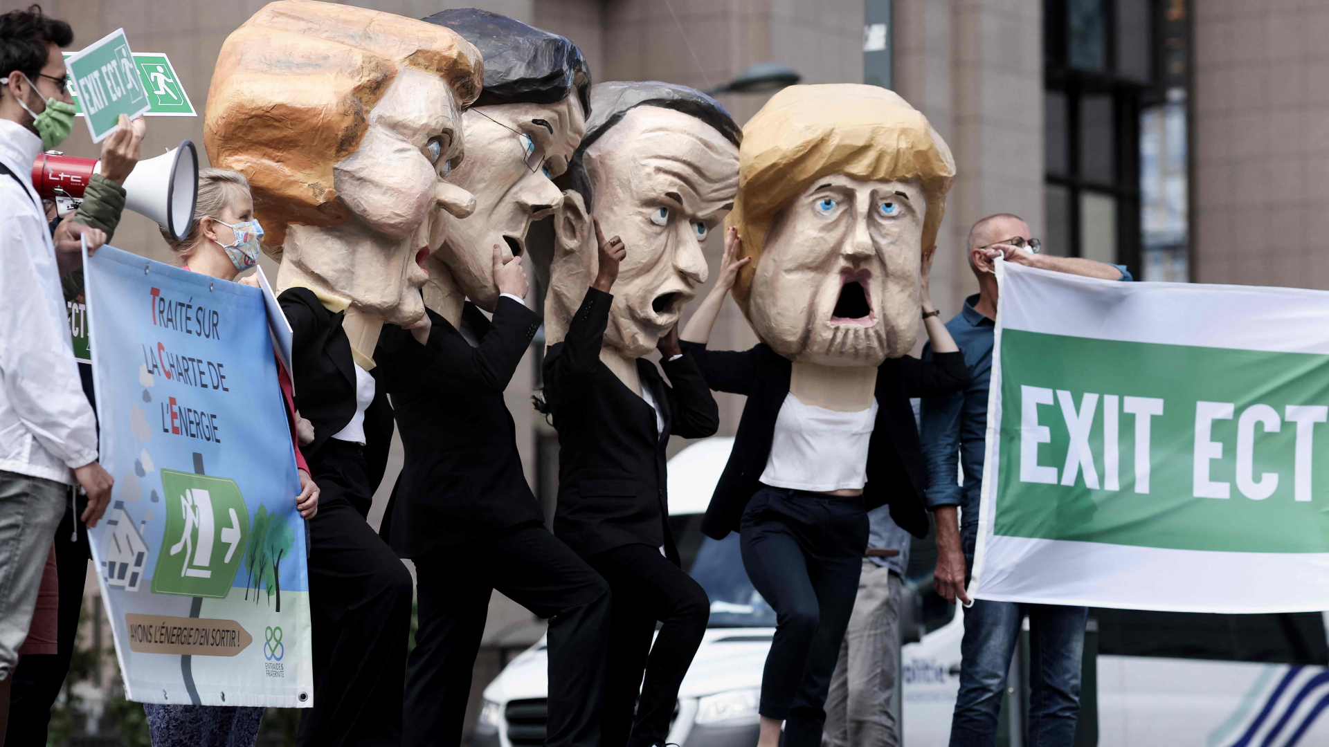 Klimaaktivisten mit Masken der EU-Politiker Ursula von der Leyen, Mark Rutte, Emmanuel Macron und Angela Merkel  | AFP