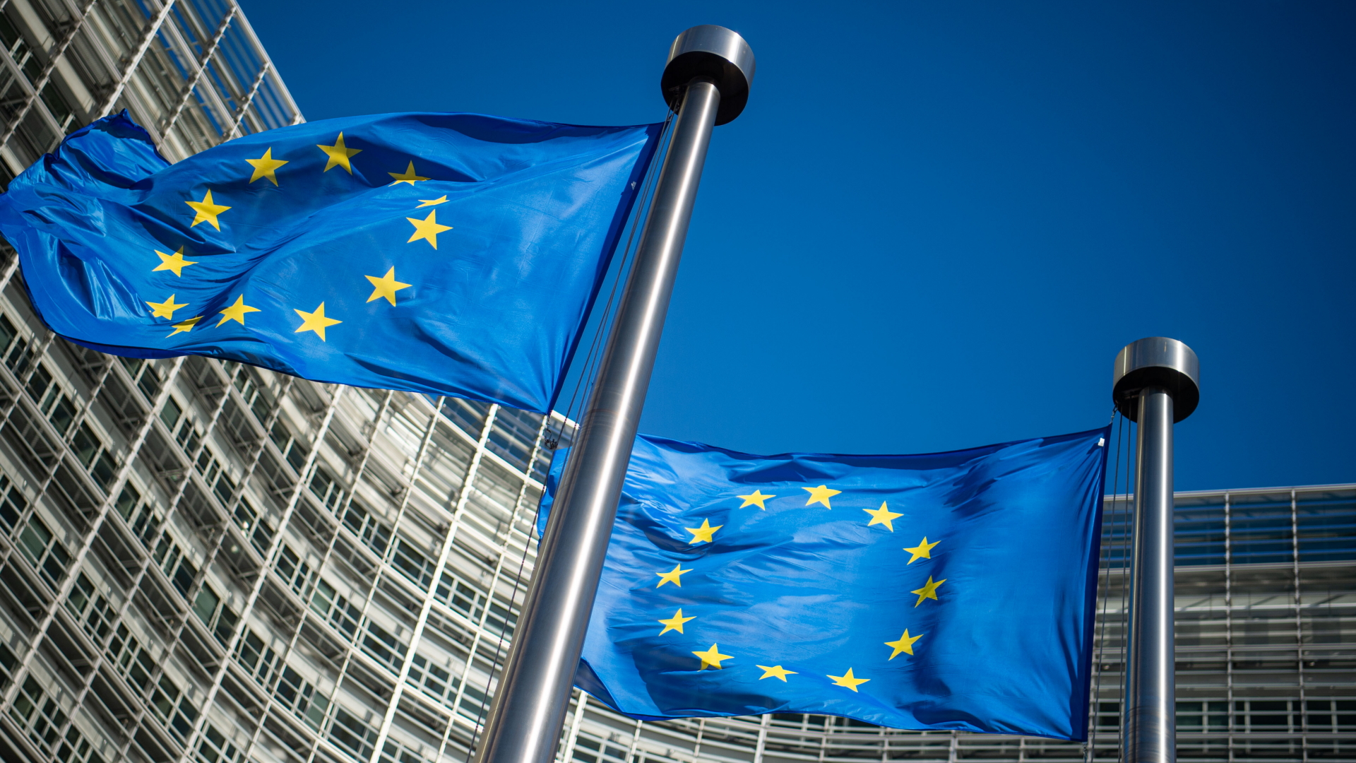 Flaggen wehen vor dem Gebäude der EU-Kommission in Brüssel. | dpa