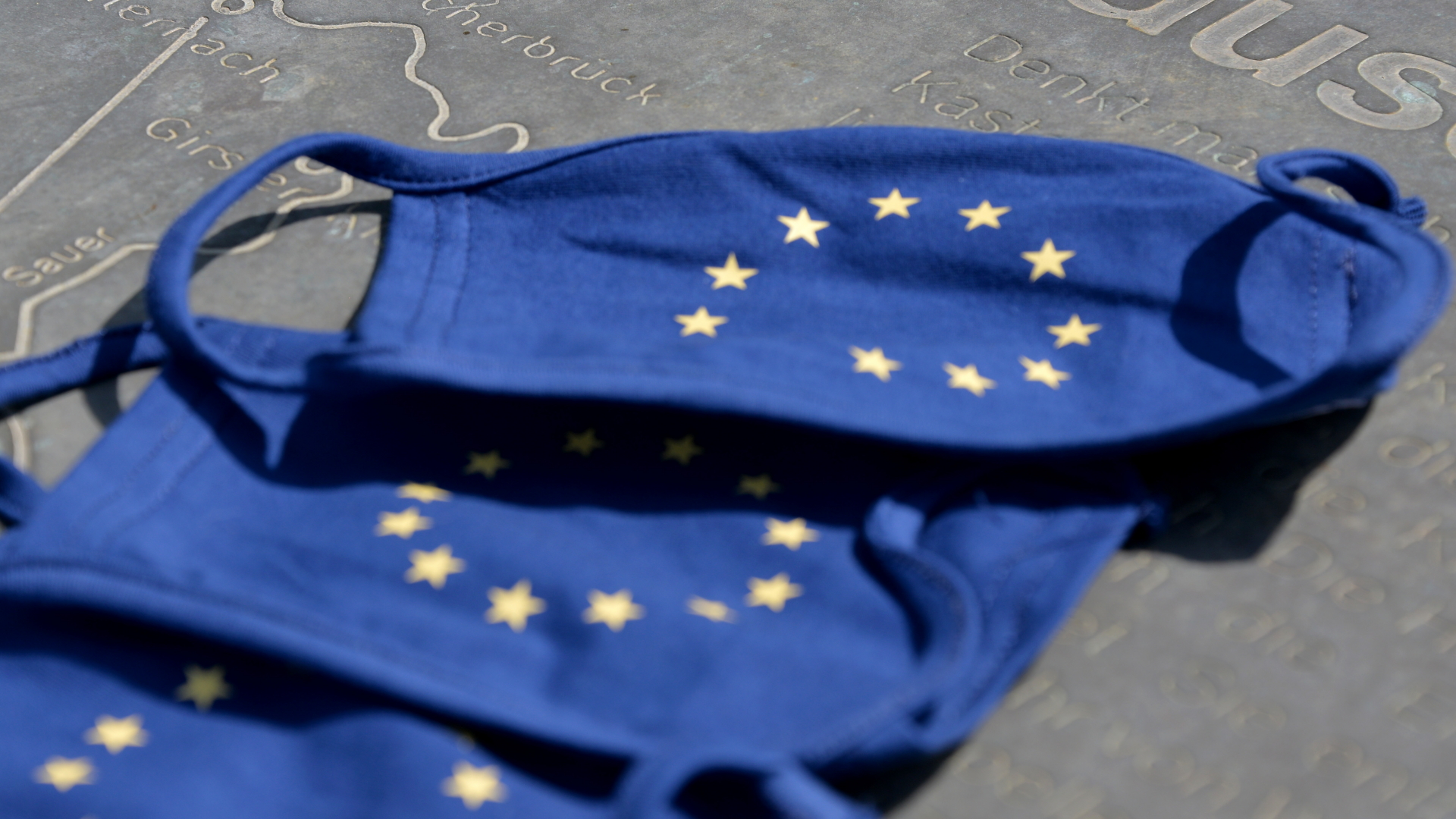 Blaue Mund- und Nasenschutzmasken mit dem Symbol der Europäischen Union, den Sternen im Kreis
