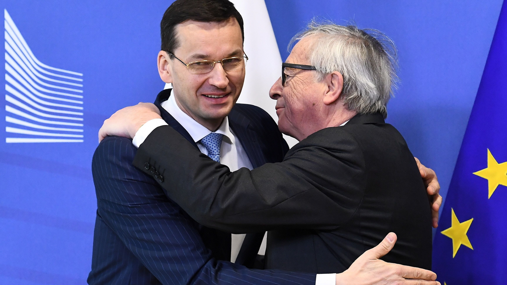 Polens Premier Morawiecki und EU-Kommissionschef Juncker umarmen sich zur Begrüßung in Brüssel. | AFP