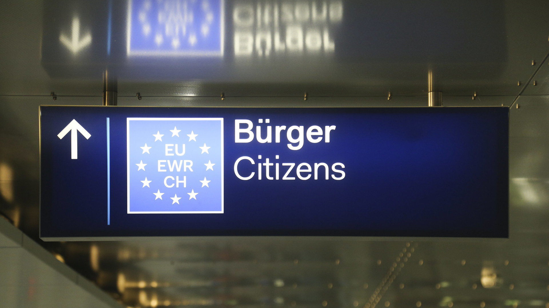 Ein Schild im Bereich für ankommende Flugreisende am Flughafen Düsseldorf weist EU-Bürgern den Weg zur Passkontrolle. | picture alliance / NurPhoto