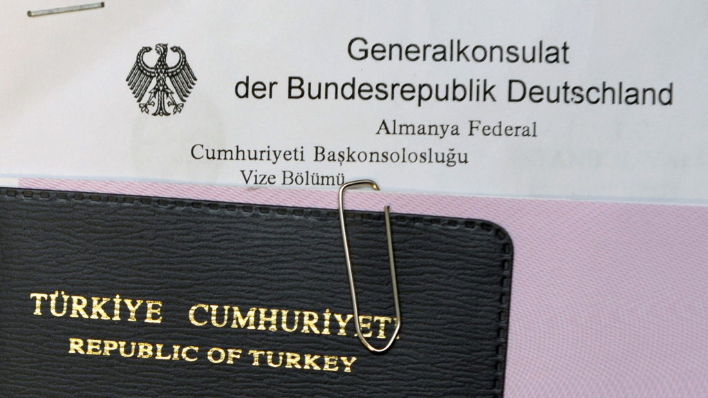 Ein türkischer Reisepass liegt auf einem deutschen Formular
