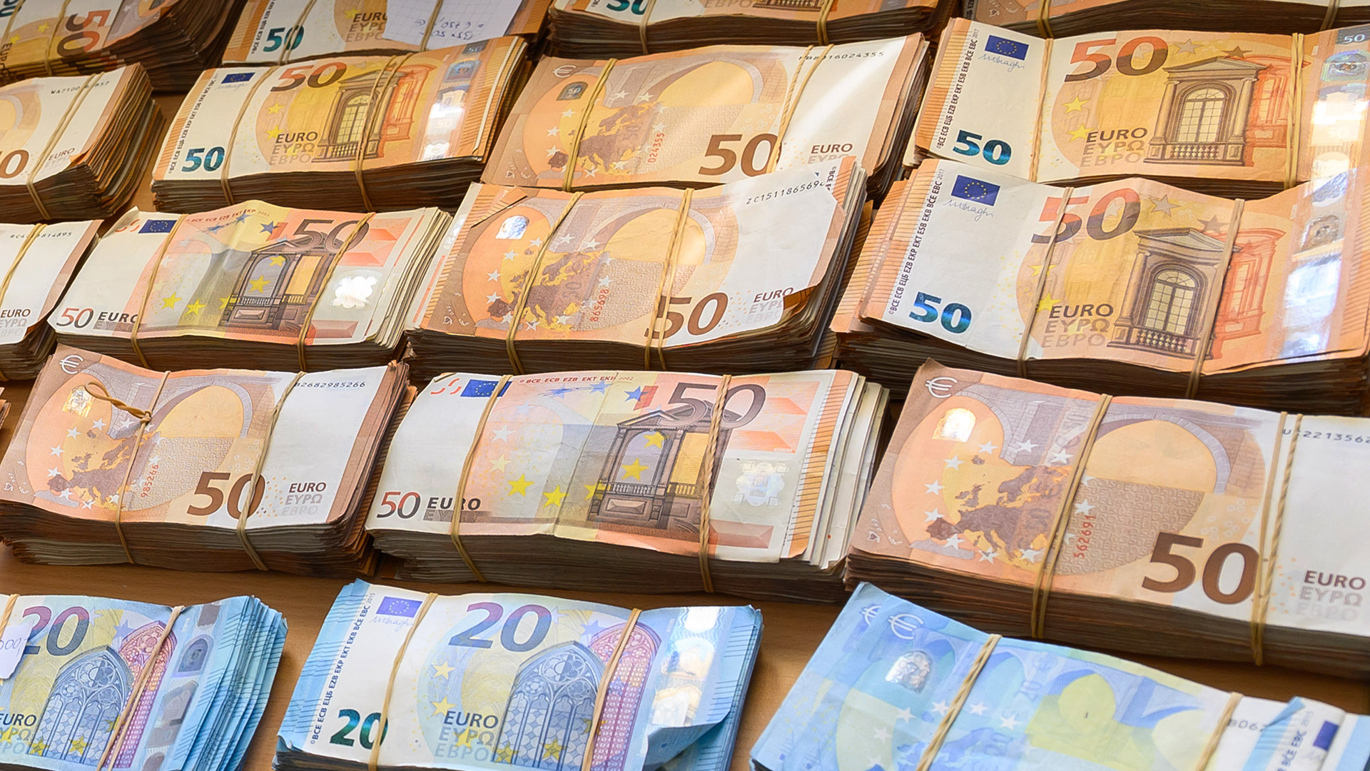 Geldbündel aus 50er und 20er Euro Scheinen liegen auf einem Tisch | dpa
