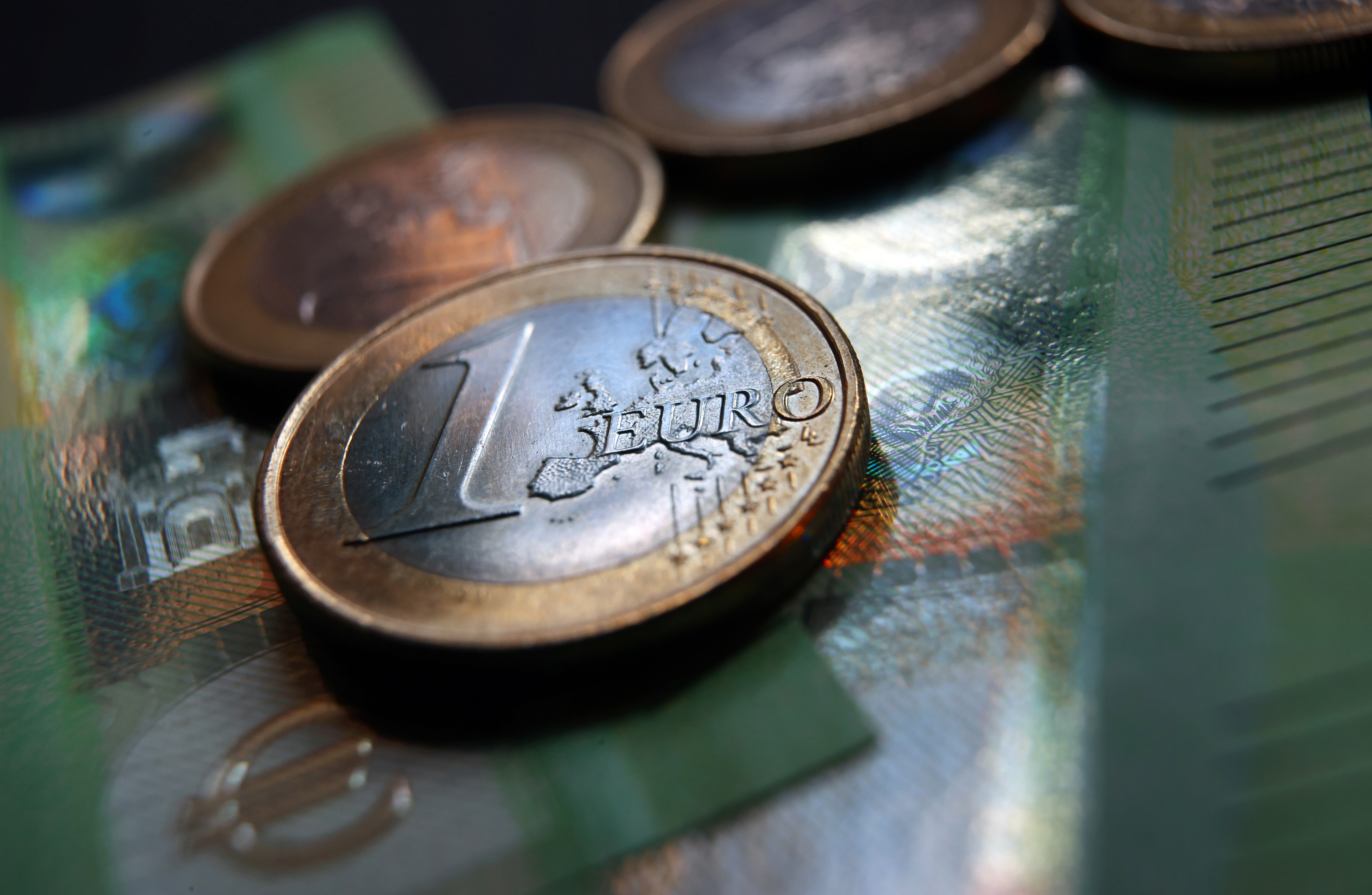 Euro-Münzen und Geldscheine liegen auf einem Tisch | dpa