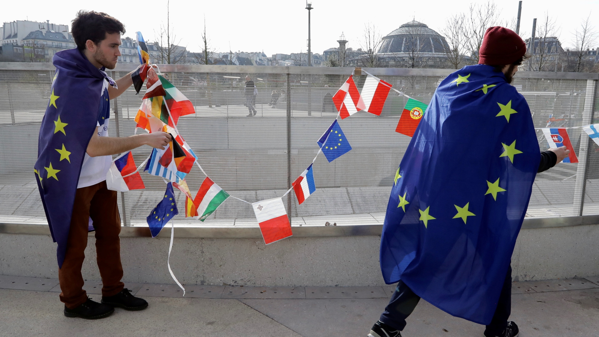 Zwei Männer tragen eine Girlande mit europäischen Flaggen während der "Pulse of Europe" Demonstration in Paris