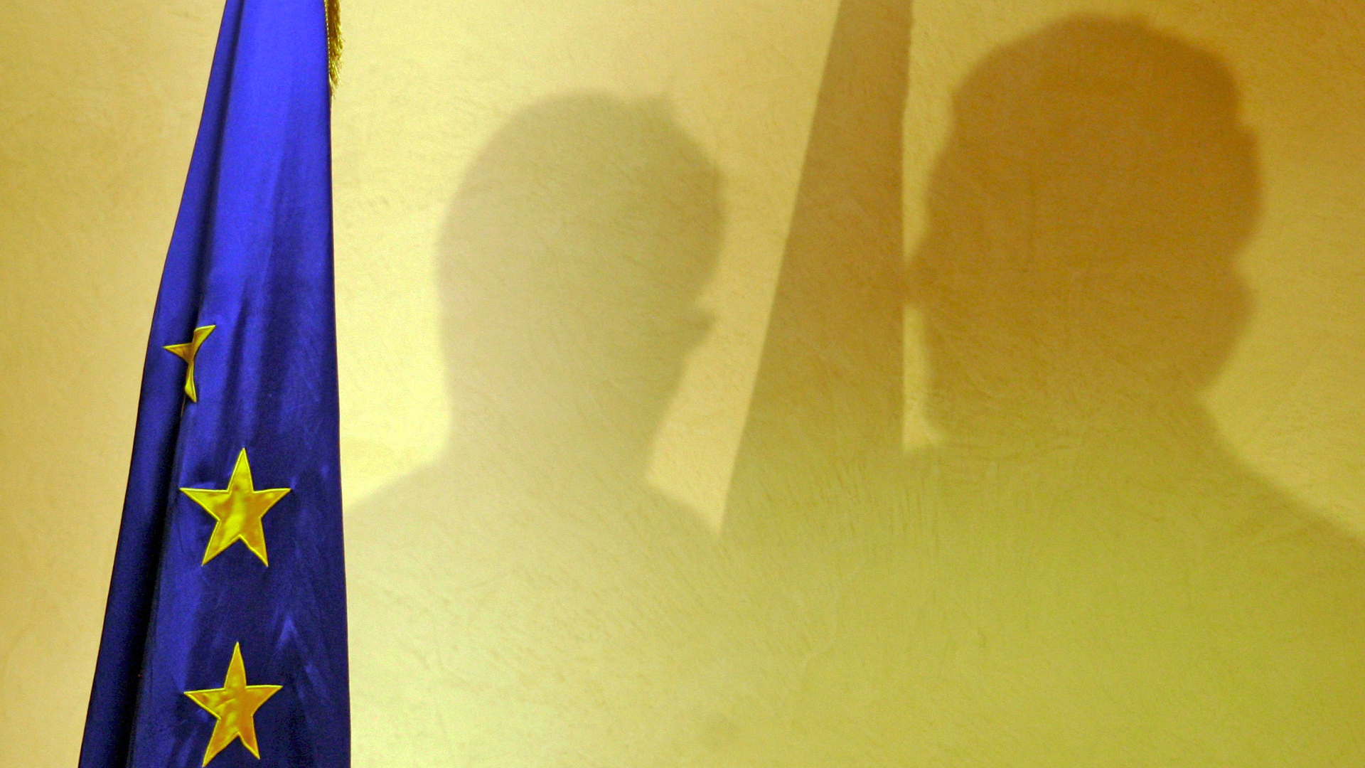 Schatten von Personen neben einer EU-Flagge | picture-alliance/ dpa/dpaweb
