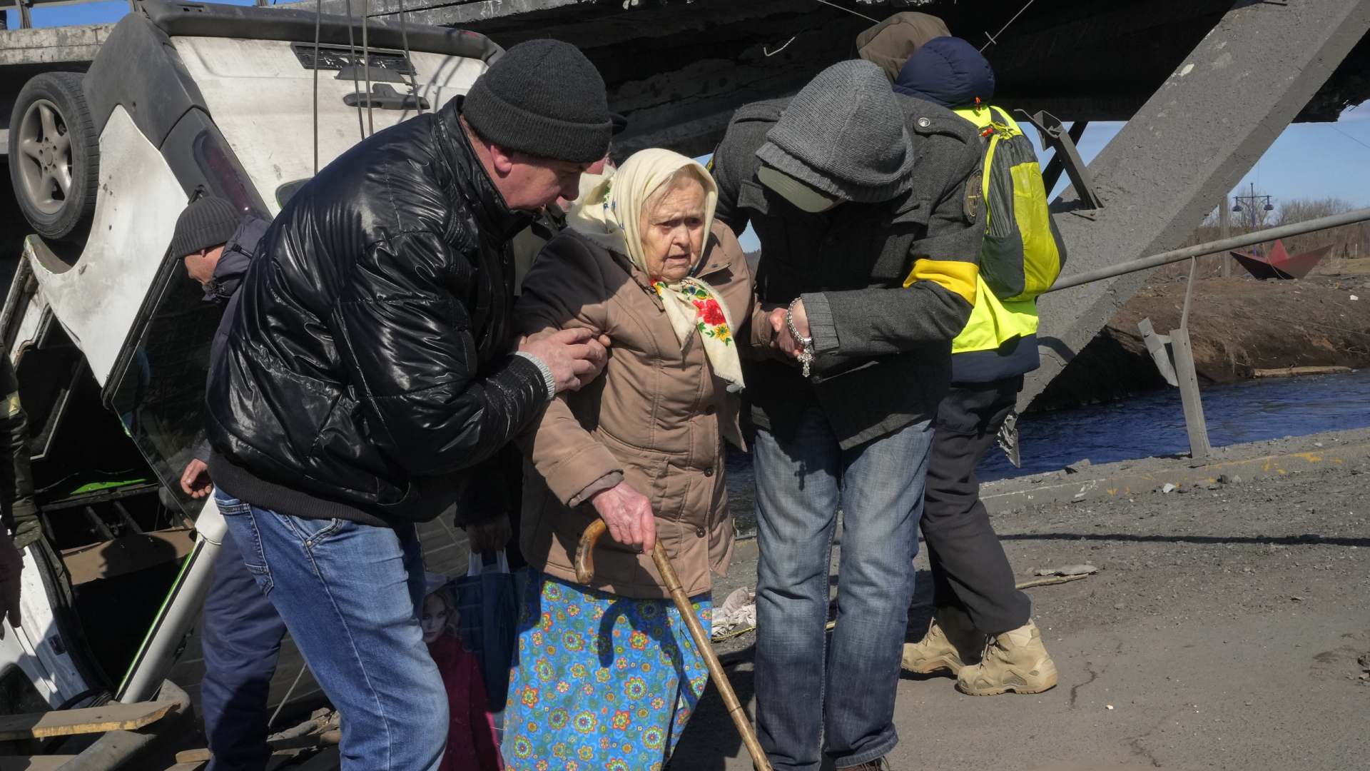 Freiwillige helfen einer alten Frau bei der Flucht aus der zerstörten Stadt Irpin nordwestlich von Kiew. | AP