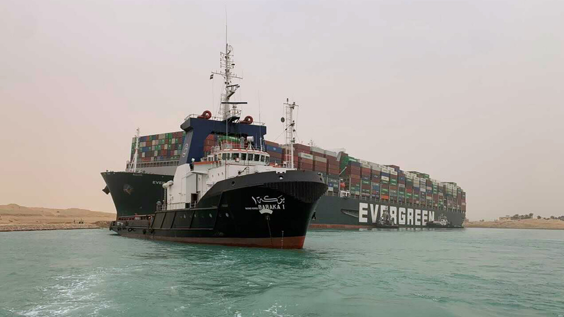 Ein Schlepper vor dem havarierten Containerschiff "Ever Given" im Suezkanal.