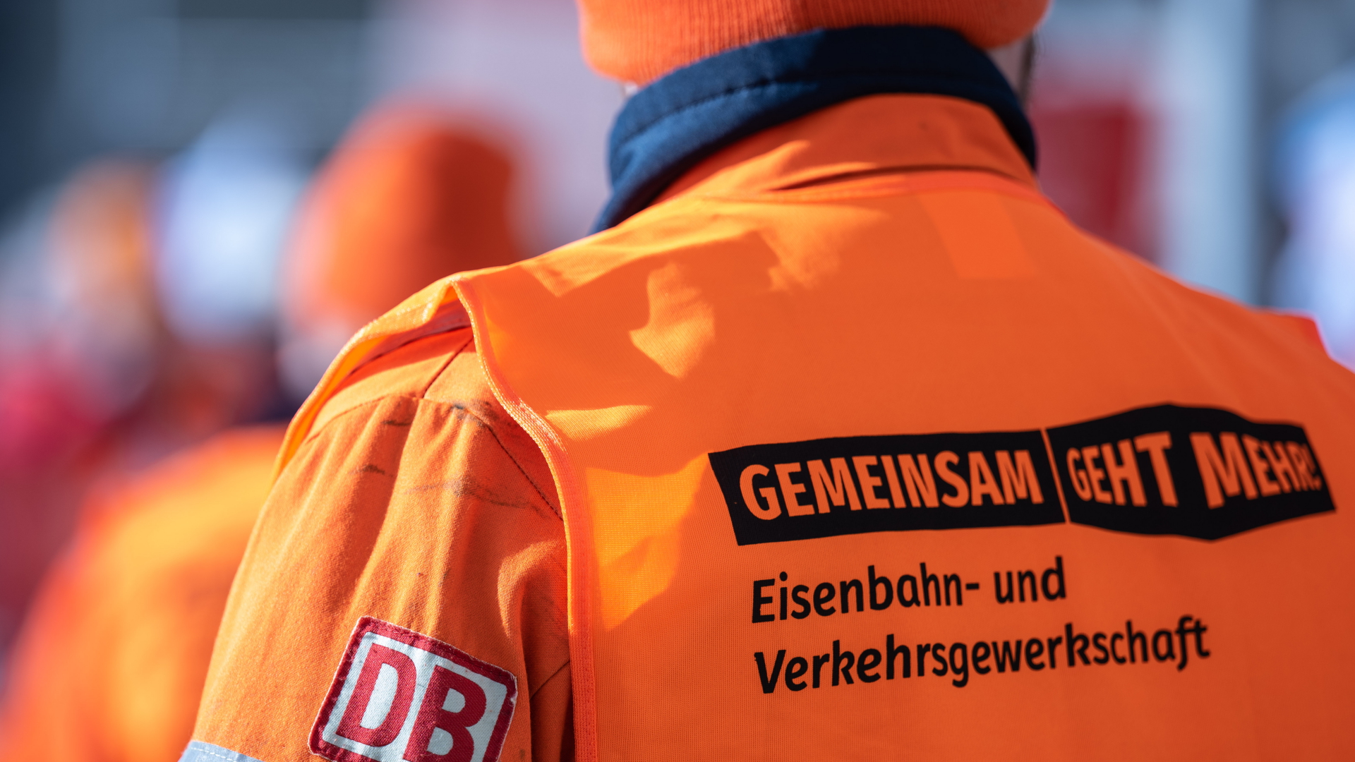 Ein Bahnmitarbeiter beteiligt sich in einer Weste der Eisenbahn- und Verkehrsgewerkschaft (EVG) in Halle/Saale an einer Kundgebung zum Warnstreik.  | dpa