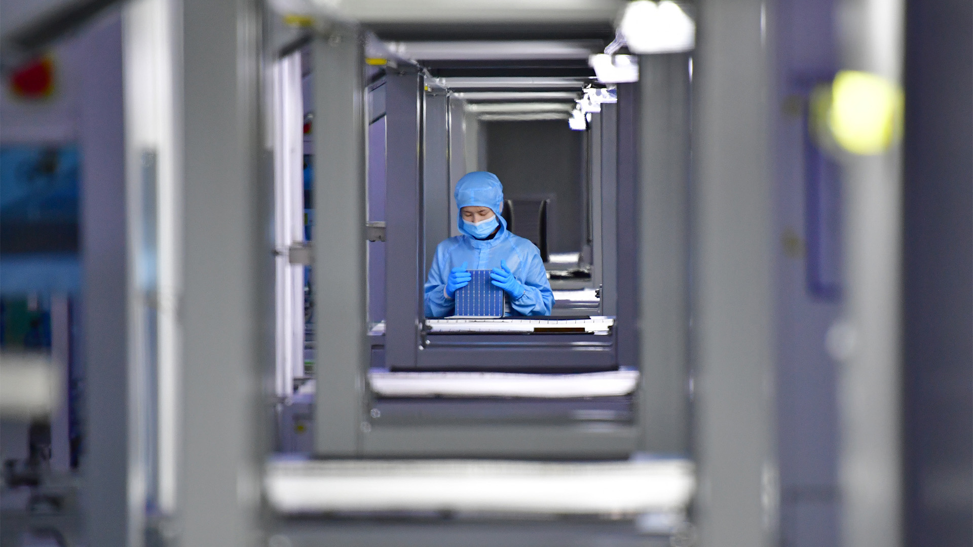 Ein Mitarbeiter untersucht einen Zellwafer in einer Fabrik für monokristalline Silizium-Solarzellen. | dpa