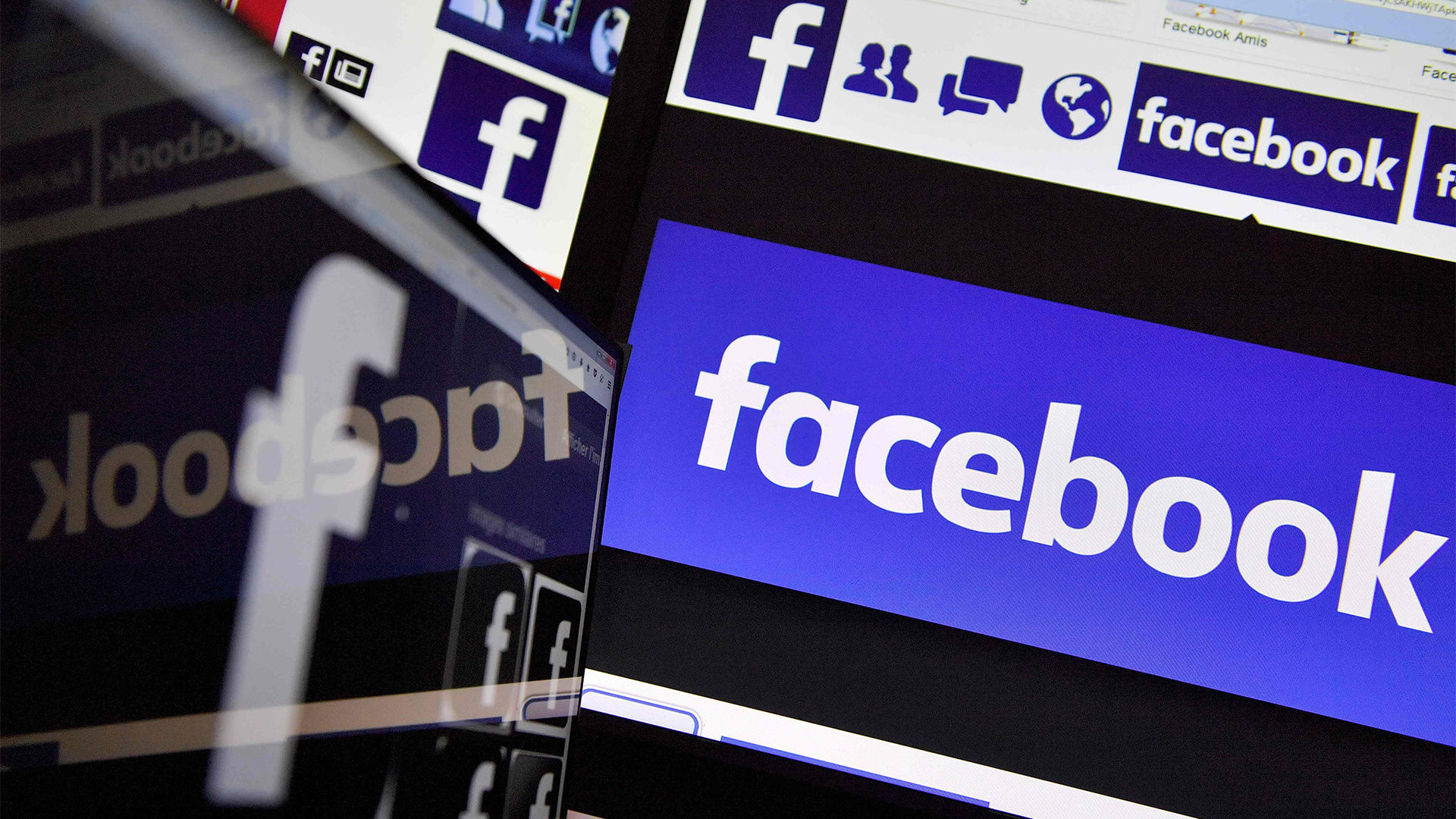 Ein Facebook-Logo spiegelt sich auf einem Monitor. | AFP
