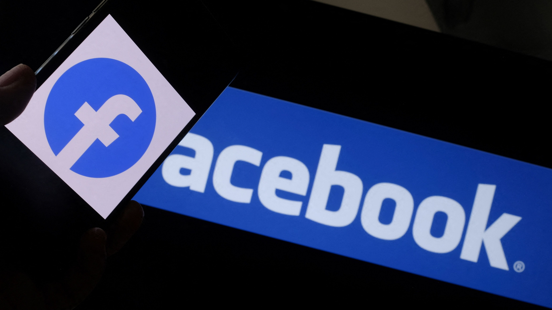 Facebook-Logo auf einem Smartphone vor einem Computerbildschirm | AFP