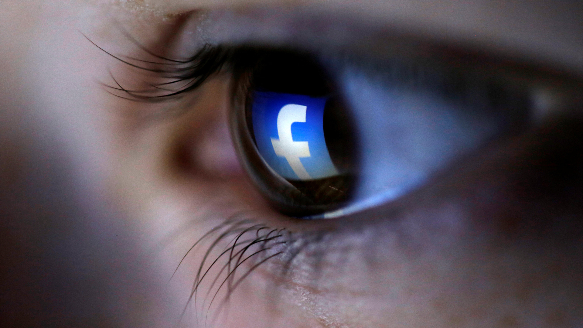 Das Facebook-Icon spiegelt sich in einer Pupille