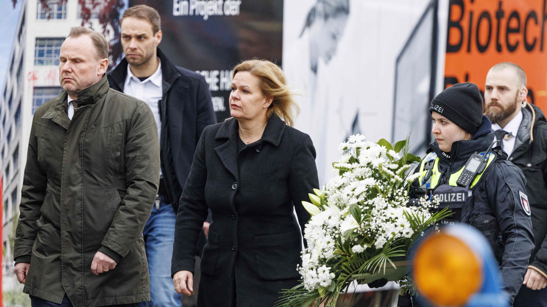 Andy Grote und Nancy Faeser mit einem Blumenkranz beim Besuch des Tatorts des Amoklaufs in Hamburg.