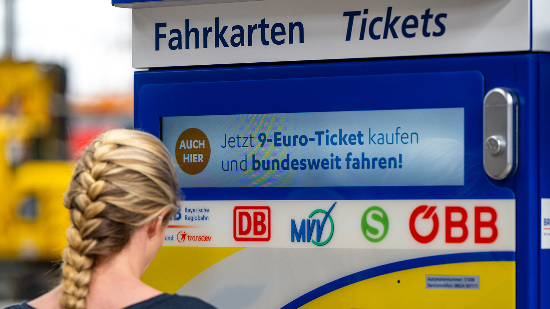 Eine junge Frau steht am Hauptbahnhof an einem Fahrkartenautomaten, auf dem Werbung für das 9-Euro-Ticket zu sehen ist.  | dpa