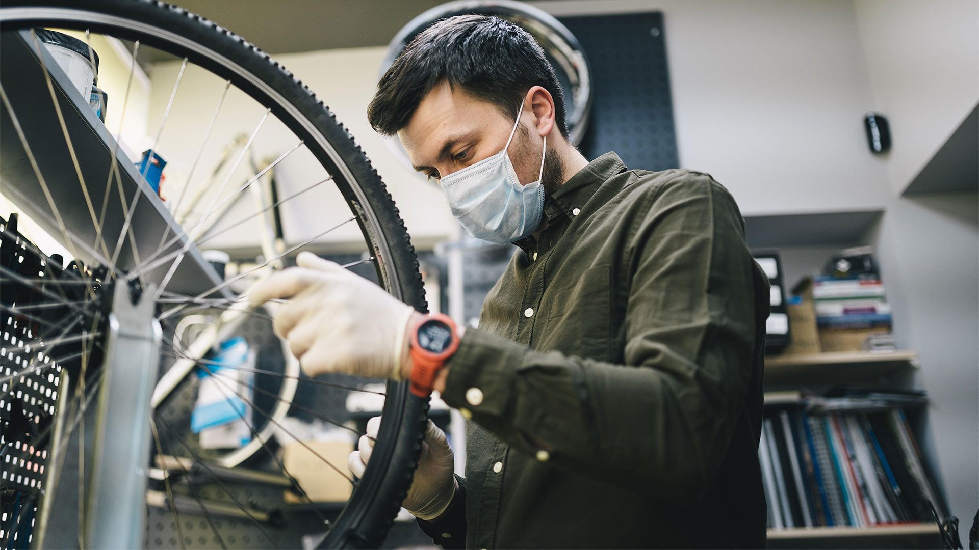 Ein Mann repariert ein Fahrrad in einer Fahrradwerkstatt. | picture alliance / Zoonar