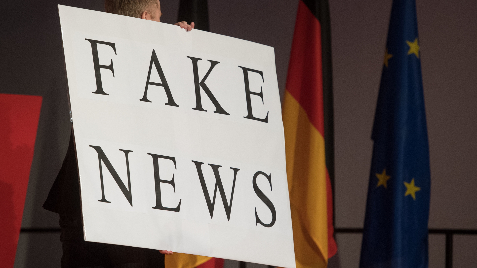 Ein Mann trägt beim politischen Aschermittwoch der baden-württembergischen CDU ein Schild mit der Aufschrift "Fake News".